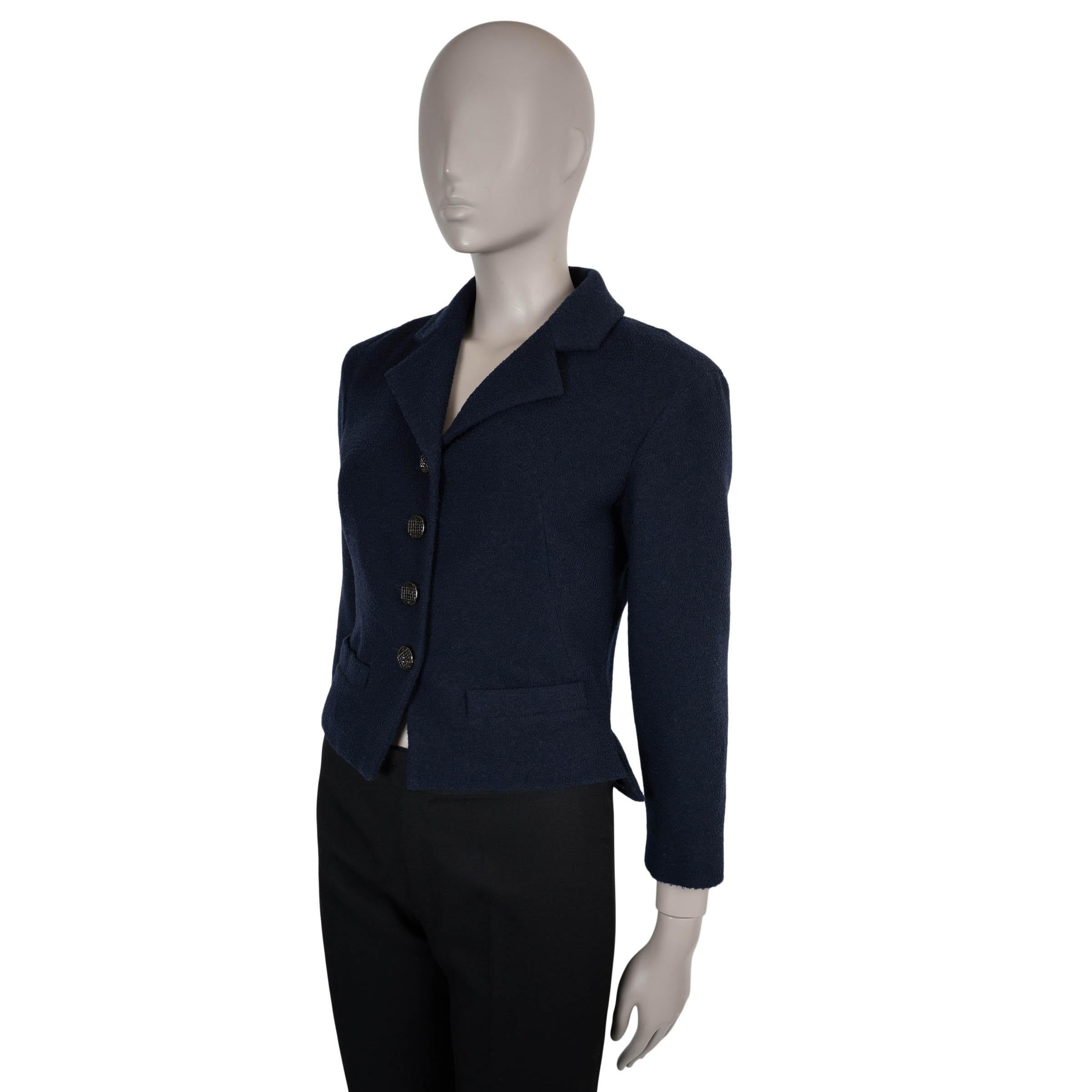 This 100% authentic Chanel jacket in navy blue tweed wool (76%), nylon (13%), and silk (11%) embodies timeless sophistication with impeccable craftsmanship. Designed with a short, fitted silhouette, it features classic notched lapels and two elegant