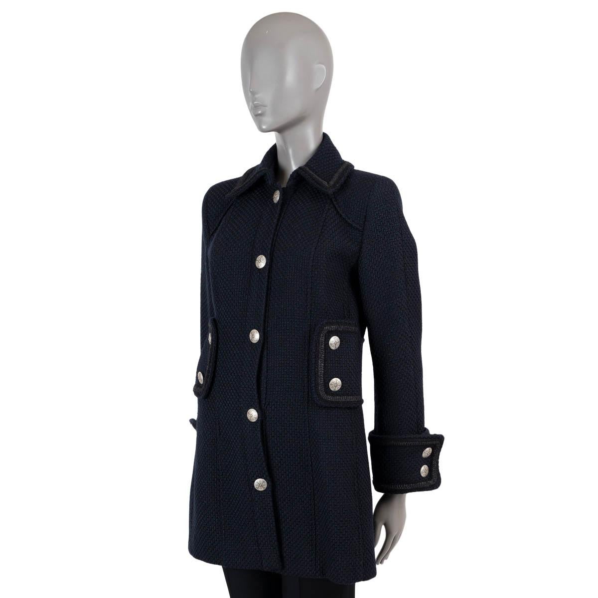 100% authentic Chanel tweed peacoat in navy blue wool (100%). Features a braided trim, wide waist belt and cuff straps. Closes with gold-tone buttons on the front and is lined in silk (100%). Has been worn and is in excellent