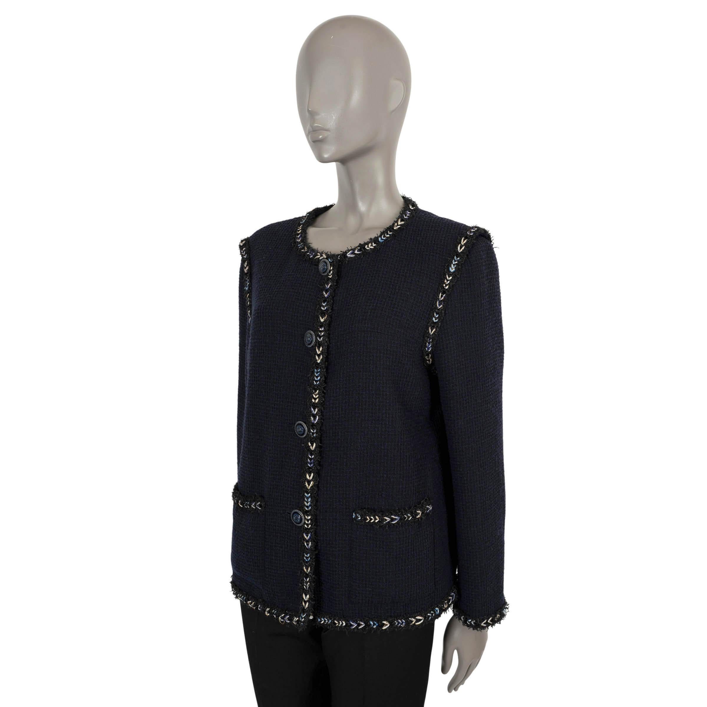 100% authentic Chanel collarless tweed jacket in navy blue wool (with 6% nylon). Features braided trims in cream and black and two patch pockets at the waist. Opens with four 'CC' buttons on the front. Lined in navy blue silk (100%) and a