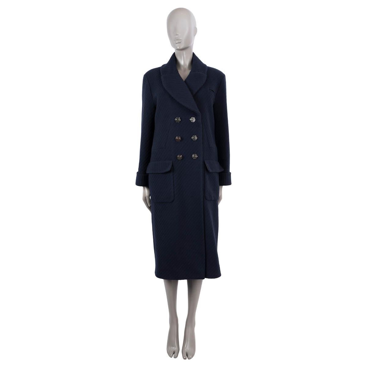 100% authentic Chanel double breasted textured coat in navy blue wool (90%) and cashmere (10%). The design features six gunmetal nut & bolt style buttons at front, two front flap patch pockets, a tiny slit chest pocket, buttoned cuffs, round lapel