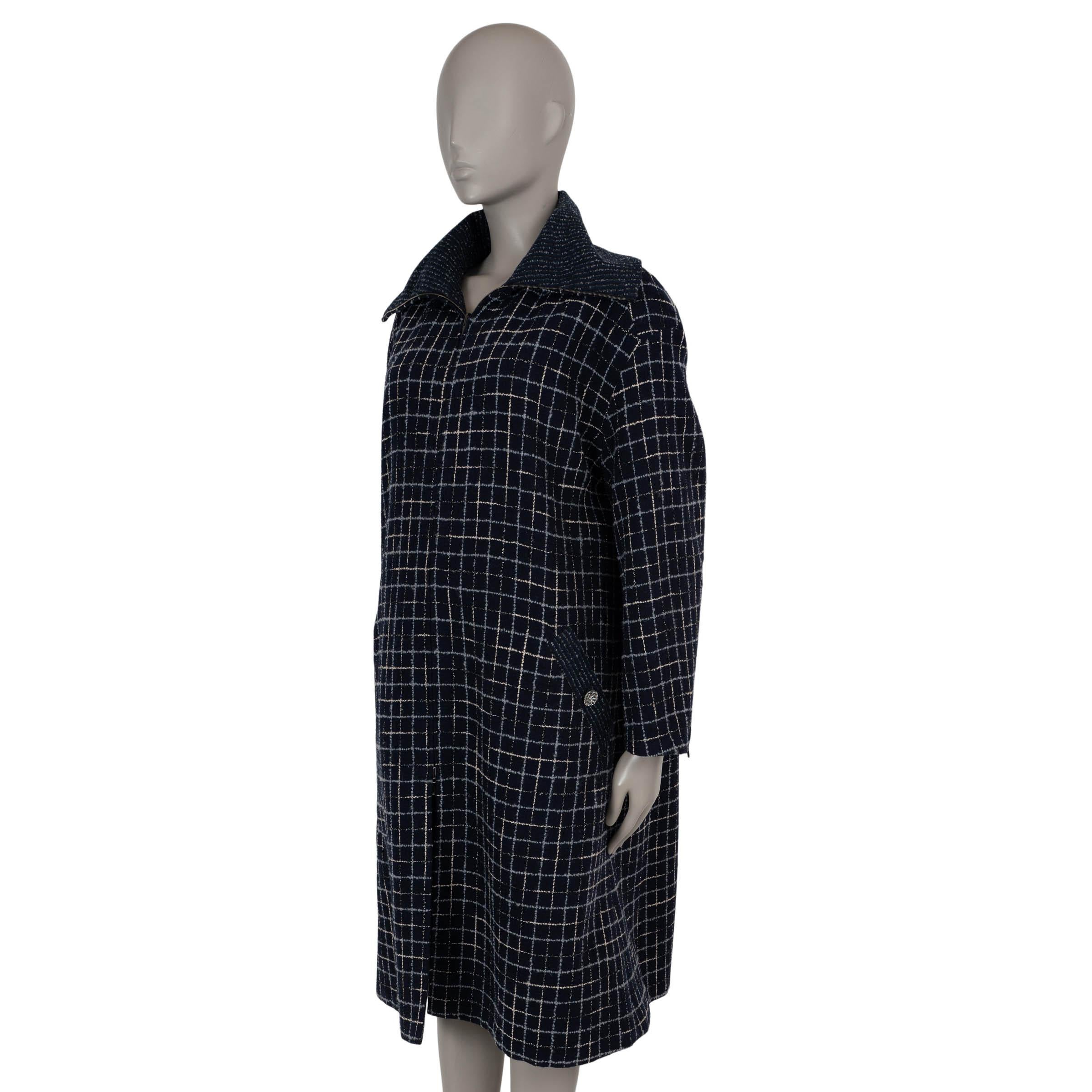 This 100% authentic Chanel coat in navy blue, grey, and white tweed wool (90%), polyester (6%), cotton (2%), acrylic (1%), and polyamide (1%) with silver lurex is a striking fusion of elegance and modern edge. Designed with an oversized, A-line