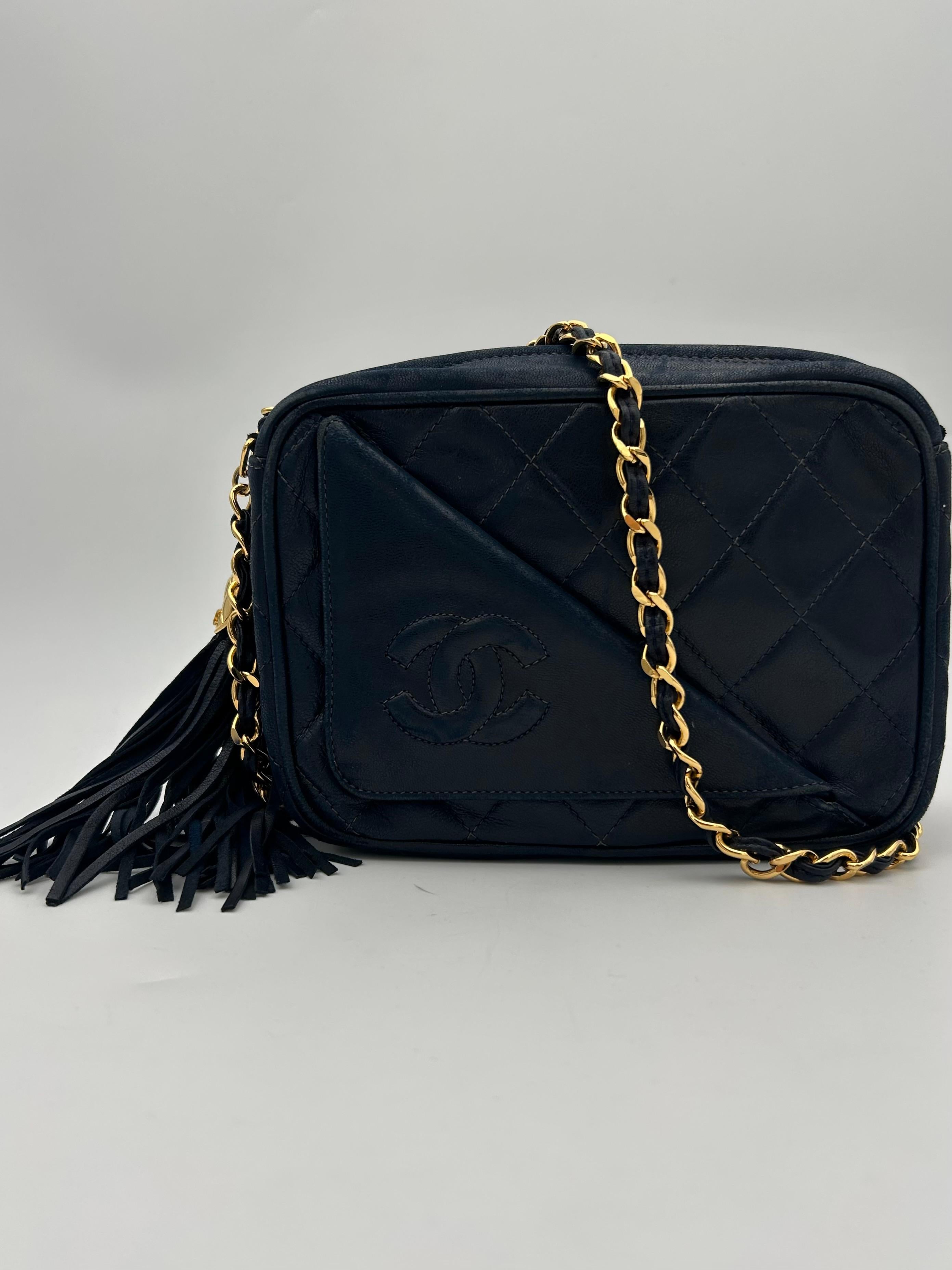 Chanel Navy Camera Front Pocket CC Tassel Bag 1990. Questa bellissima borsa fotografica è iconica e perfetta sia per il giorno che per la notte, davvero pratica: la tasca interna è spaziosa e la cerniera permette di mantenere la privacy e la
