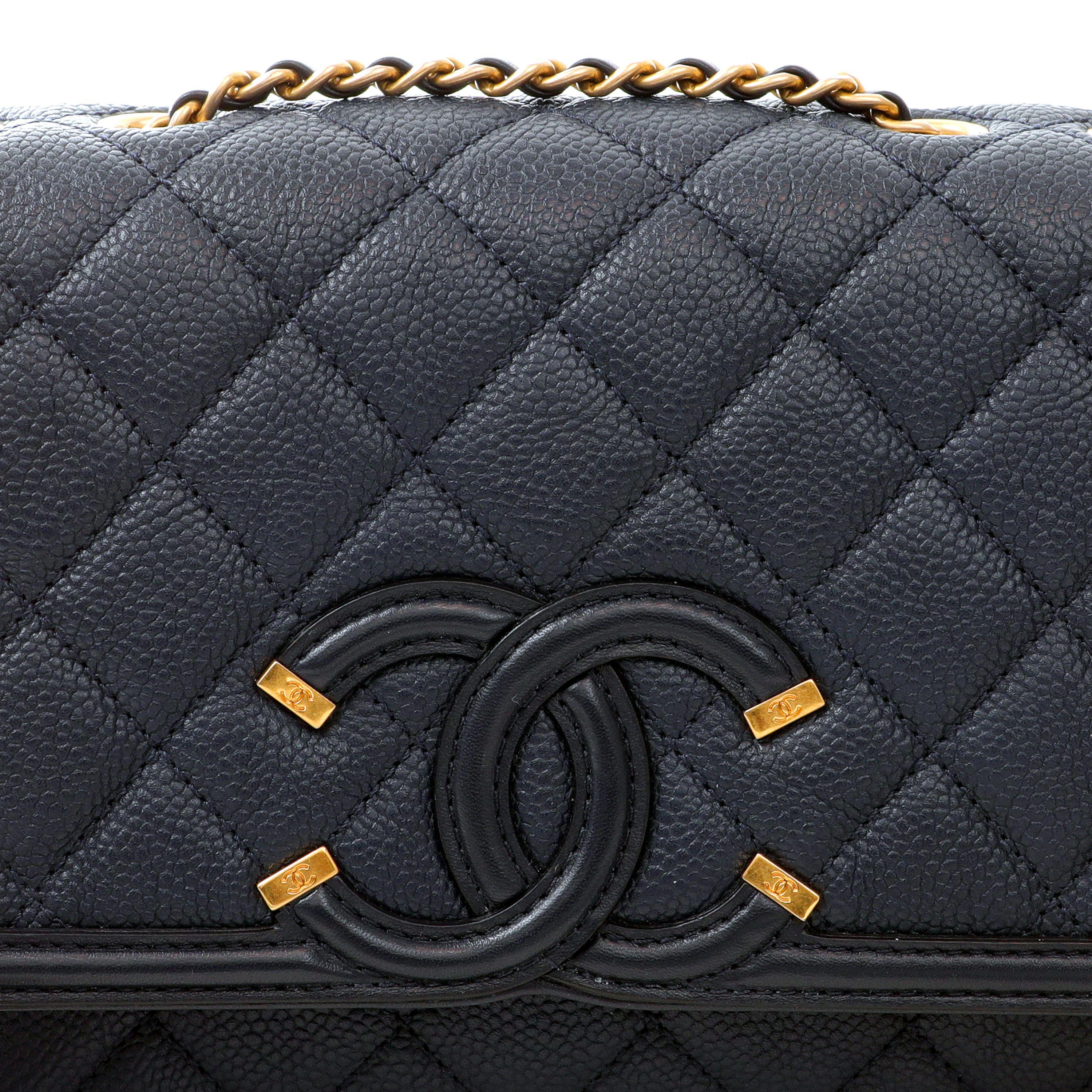 This authentic Chanel Navy Caviar Filigree Crossbody Flap Bag is pristine. Classic navy-blue caviar leather flap bag is textured and durable.  Quilted in signature Chanel diamond pattern with warm gold hardware.  Elegant leather and chain entwined