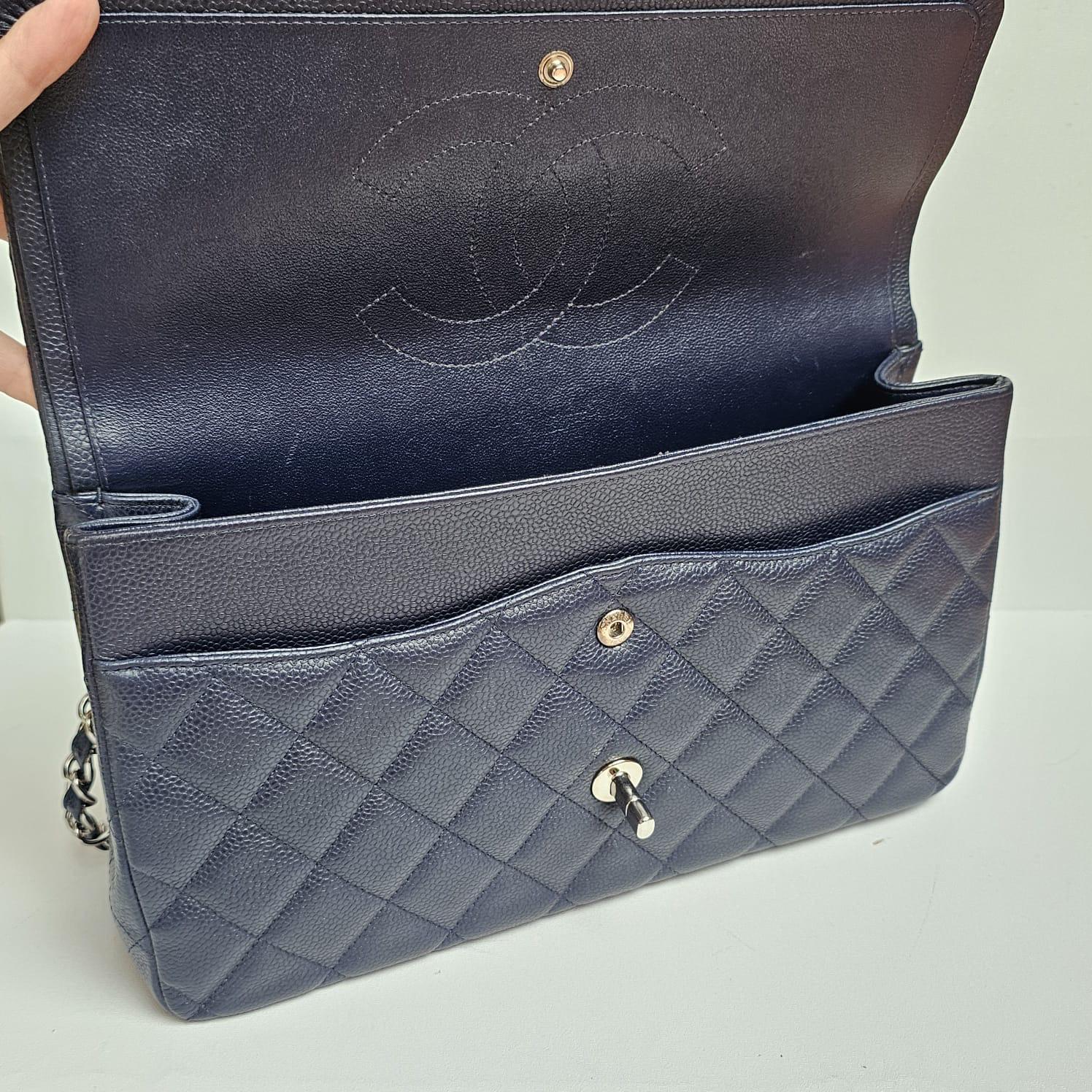 Classic jumbo flap bag in navy blue with silver hardware. Slight creasing on the leather flap with light scratches and rubbing on the corners. Lining shows light scratch marks. Series #18. Comes with the holo, card, dust bag, booklet and box.