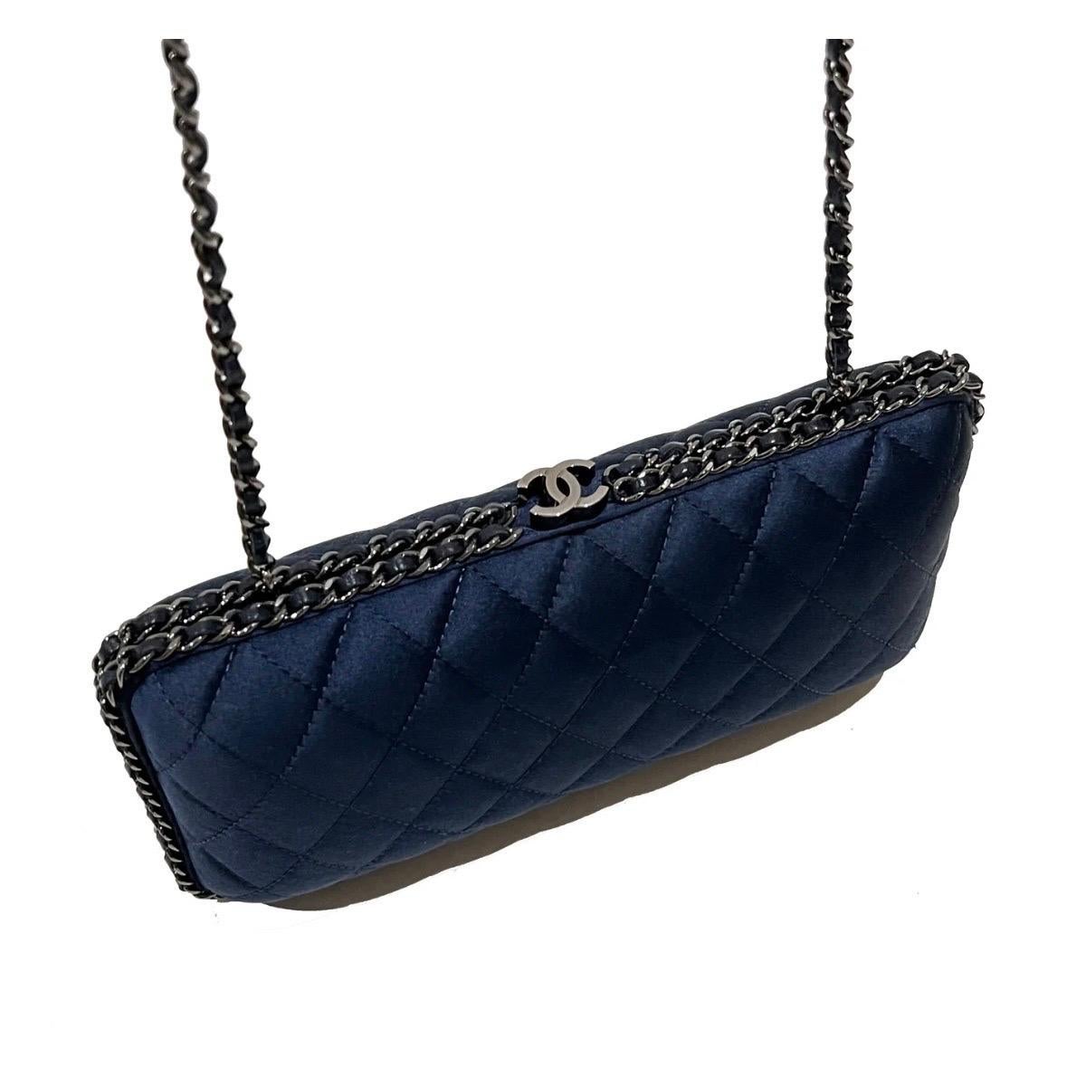 Navy Chain Around Clutch by Chanel  
Pre-Fall 2012
Navy blue quilted satin exterior 
Gun-metal toned hardware 
Top CC snap closure   
Single interior compartment 
Optional woven chain shoulder strap 
Excellent condition, no visible