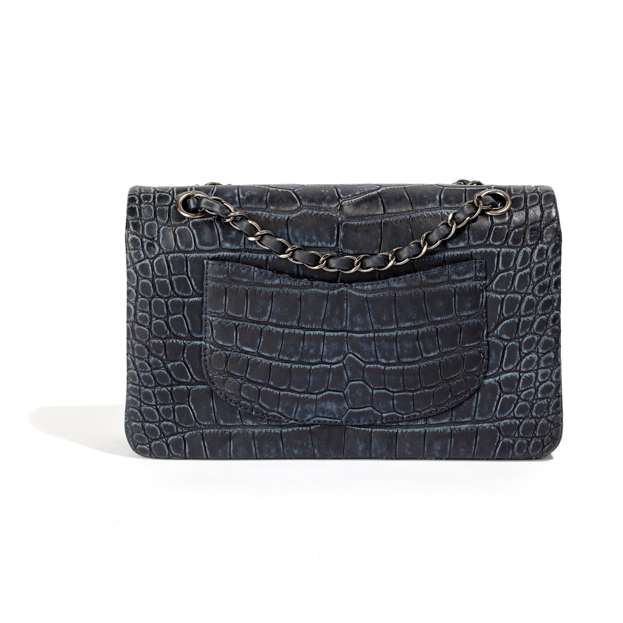 This unique and highly desirable Chanel item is skillfully crafted from navy leather. The double-flap bag has a spacious compartment and two interior pockets, offering plenty of room. The bag features a leather chain strap that can be worn as a