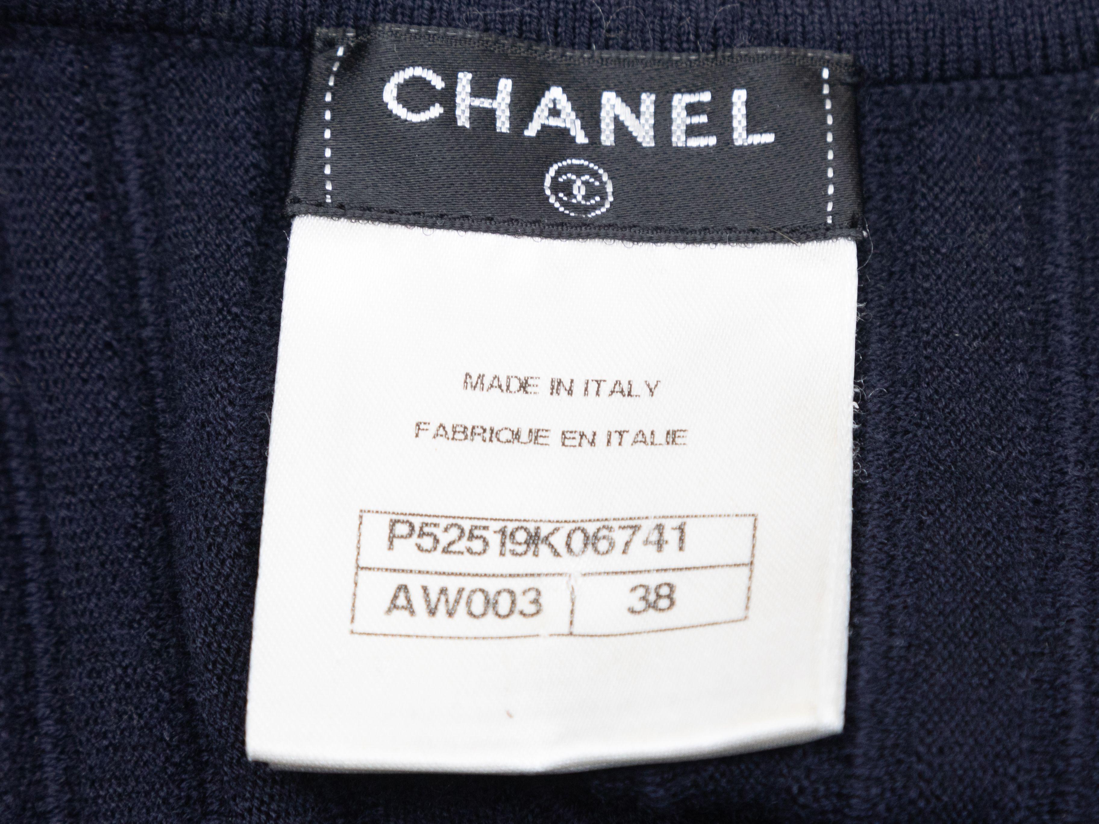 Product Details: Navy short sleeve wool knit dress by Chanel. From the Fall/Winter 2003 Collection. V-neckline. Rib knit texture throughout. Designer size 38. 26