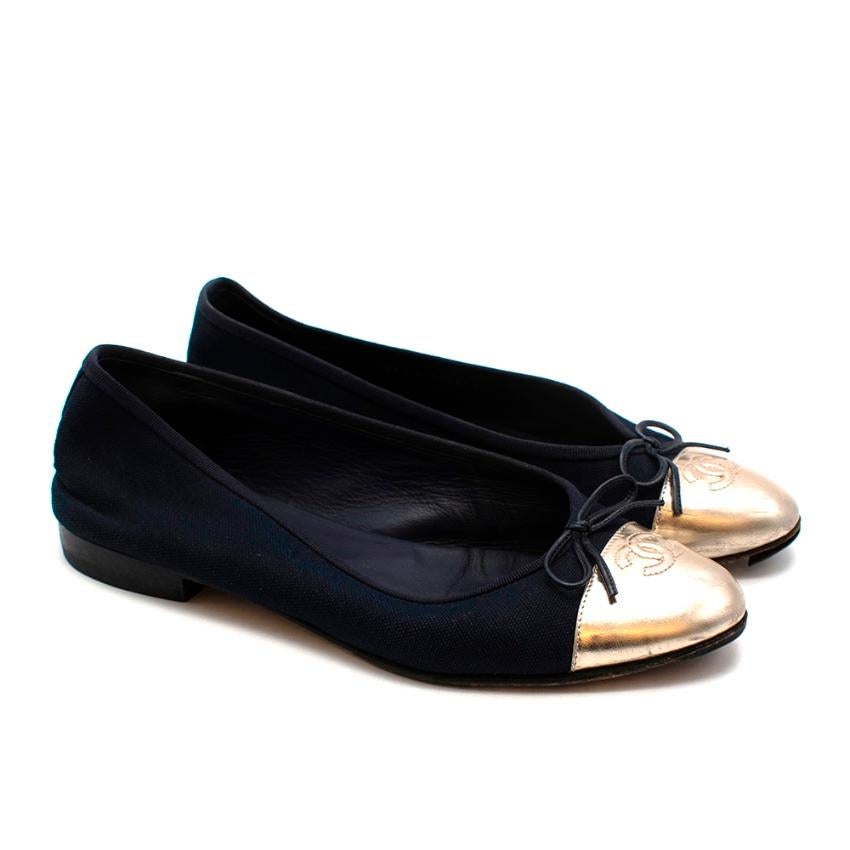 Chanel Navy & Gold Canvas & Leather CC Ballerina Flats

- Classic iconic style 
- Legendary CC logo to the toes 
- Sturdy canvas body 
- Gorgeous pale gold leather toes 
- Bow detail to the toes 
- Soft leather lining 
- Original box and dust bags