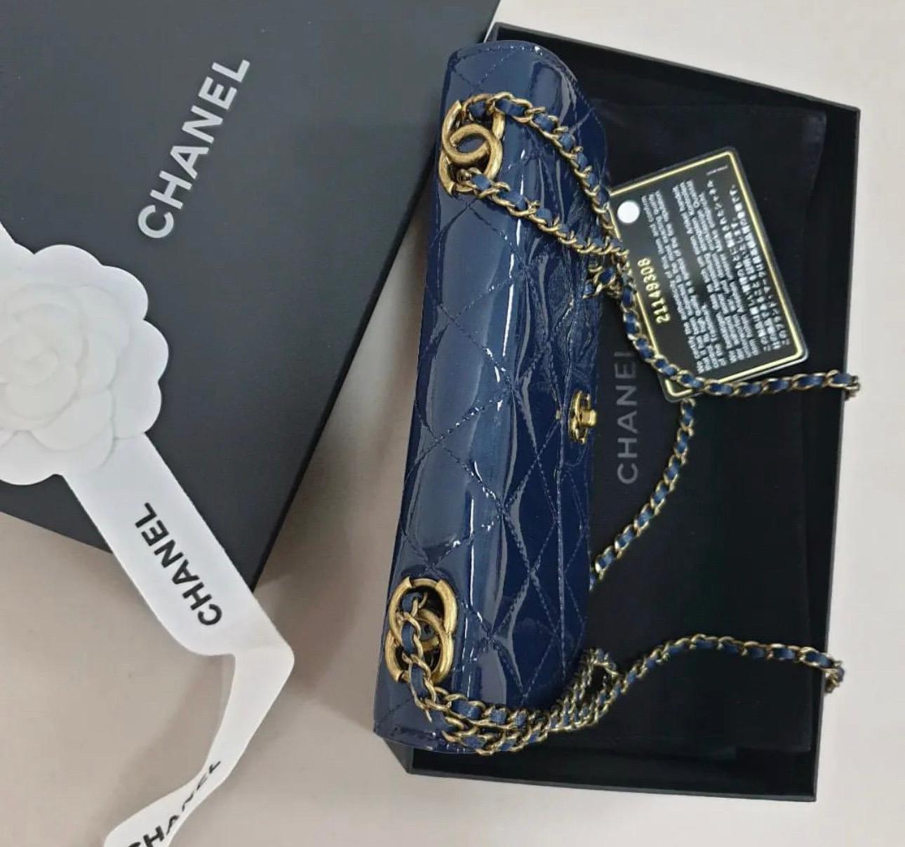 This gorgeous Chanel Navy Quilted Patent Eyelet Wallet on Chain with antiqued gold tone hardware and features a front flap with the signature CC charm closure and an antiqued gold tone chain link and navy patent leather shoulder/crossbody strap