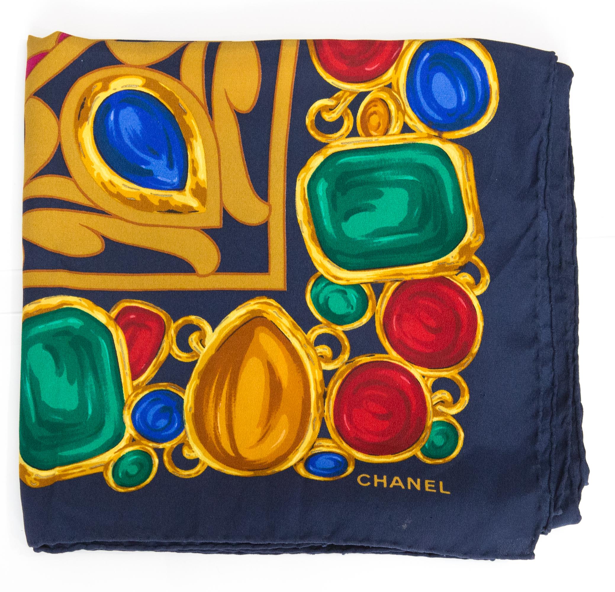 Sciarpa Chanel in seta blu scuro con stampa Jewell e logo multicolore e firma con logo in alto.
Circa anni '80
Composizione: 100% seta. 
In buone condizioni vintage. Prodotto in Francia.
37,4 pollici (95 cm) X 37,4 pollici (95 cm)
Vi garantiamo che