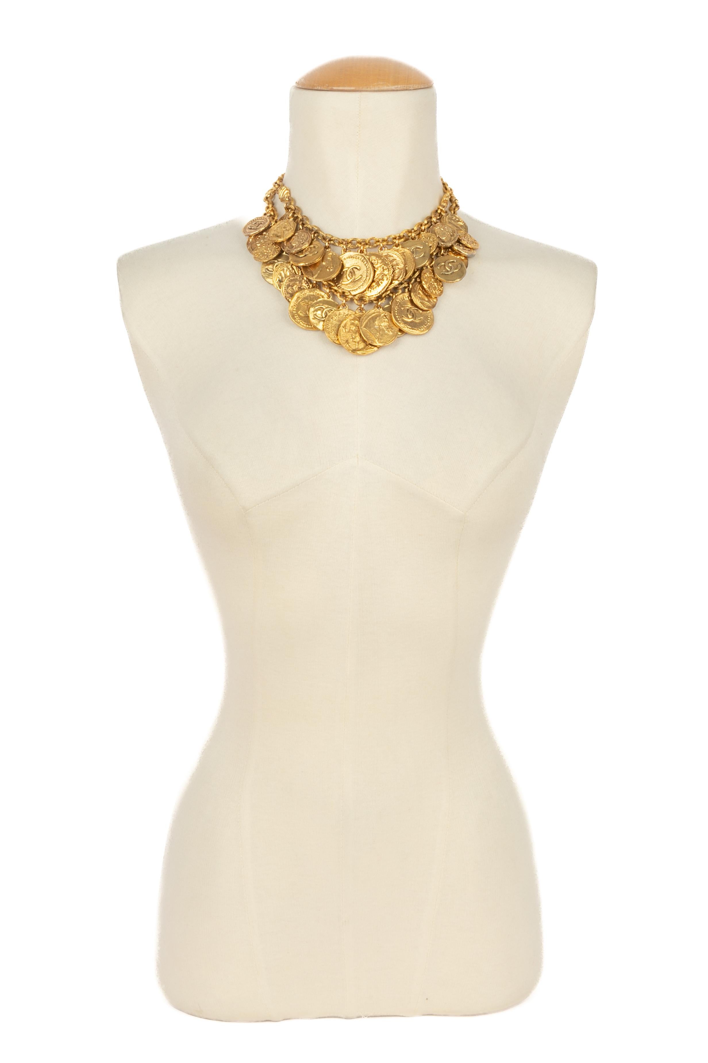 CHANEL - (Fabriqué en France) Impressionnant collier à deux rangs de chaînes en métal doré avec des pièces de monnaie. Bijoux de la fin des années 1980 - début des années 1990.

Condit :
Très bon état.

Dimensions :
Longueur de la rangée la plus