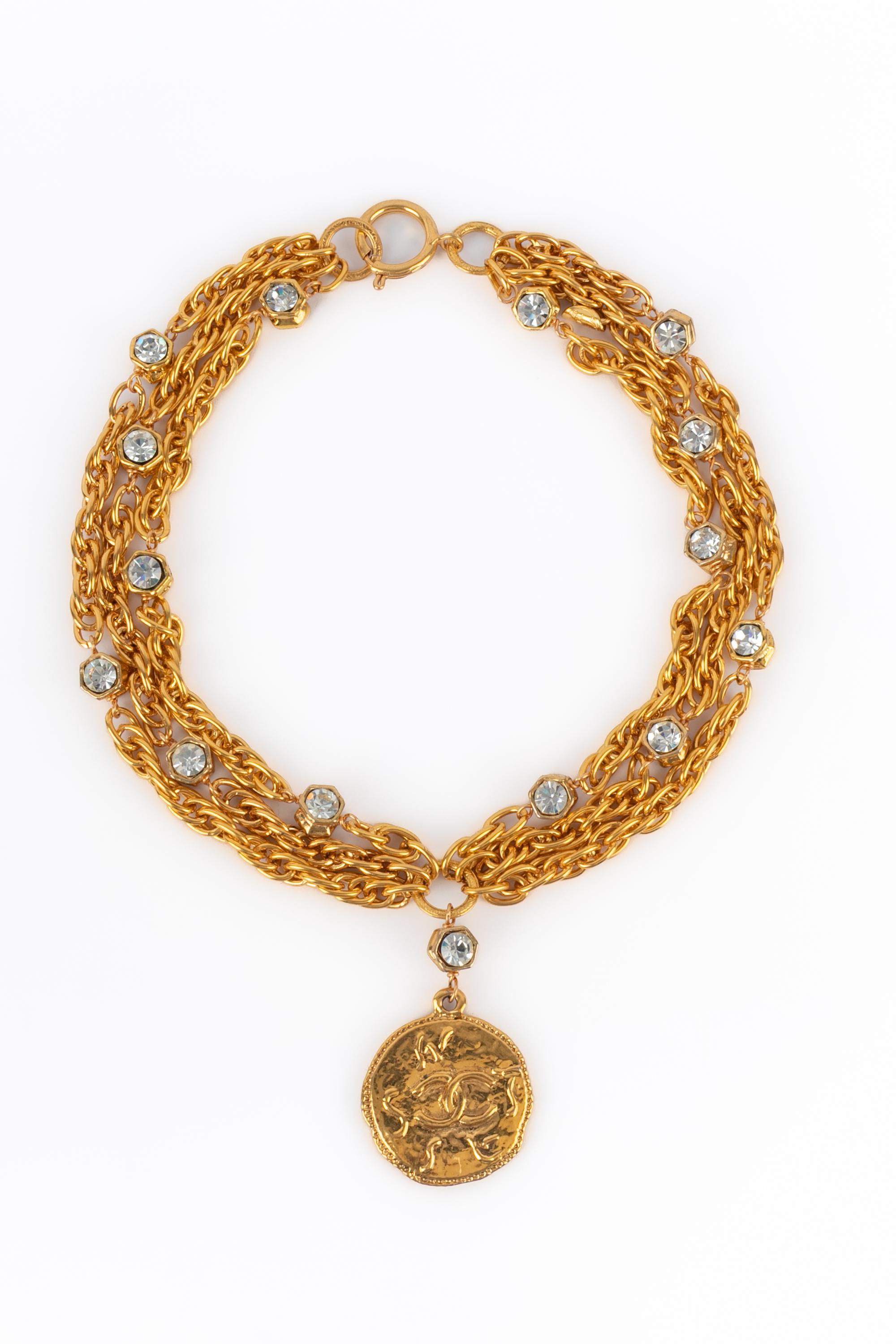 CHANEL - (Made in France) Multirow golden metal chain necklace with rhinestones and a medallion engraved with the house name.

Condition:
Very good condition

Dimensions:
Length: 43 cm

SKU:CB39