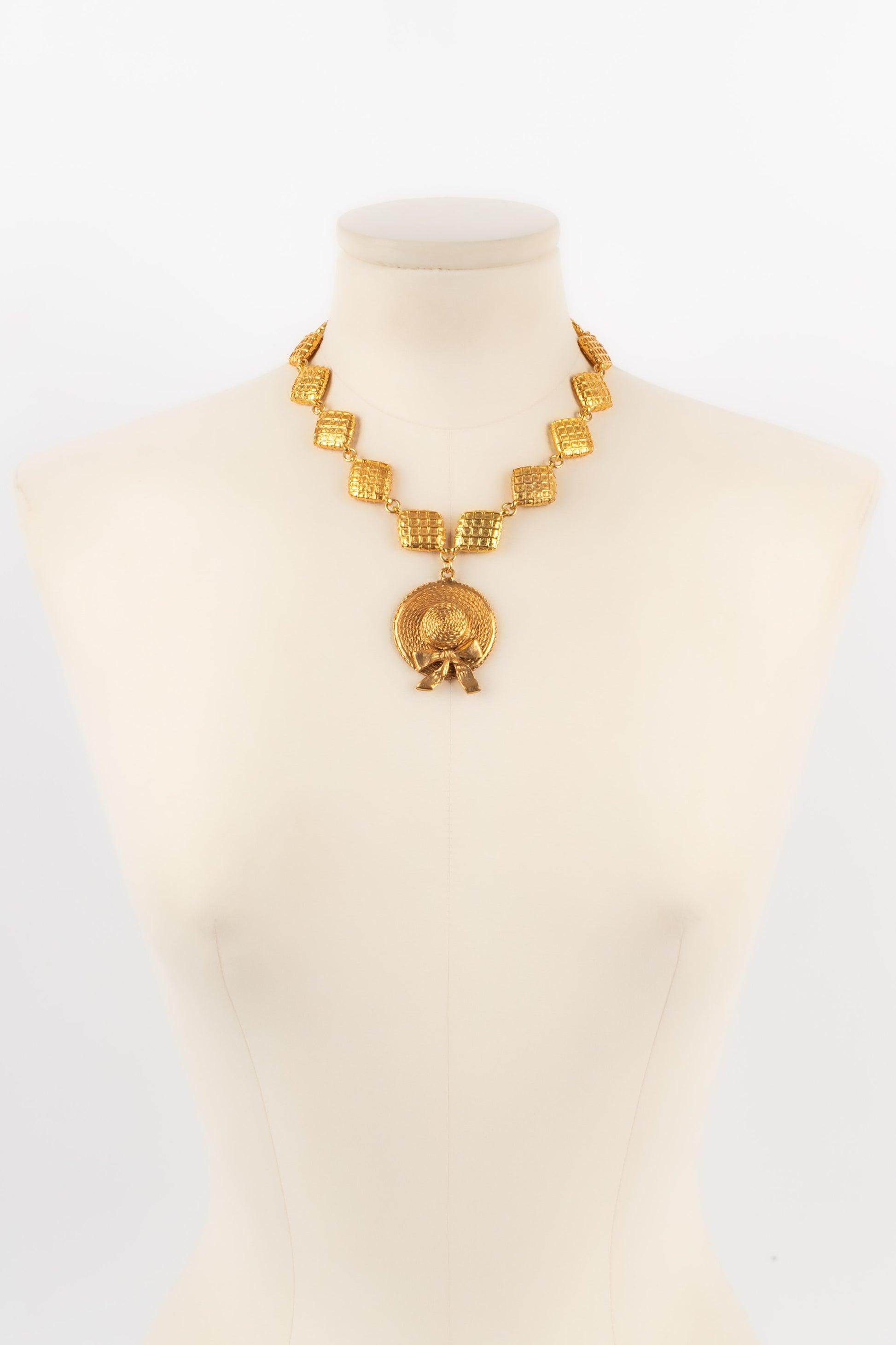 Chanel - (Made in France) Necklace in golden metal with quilted elements and centered with a hat. Jewelry from the beginning of the 1990s.

Additional information:
Condition: Very good condition 
Dimensions: Length: 42 cm

Seller Reference: CB217

