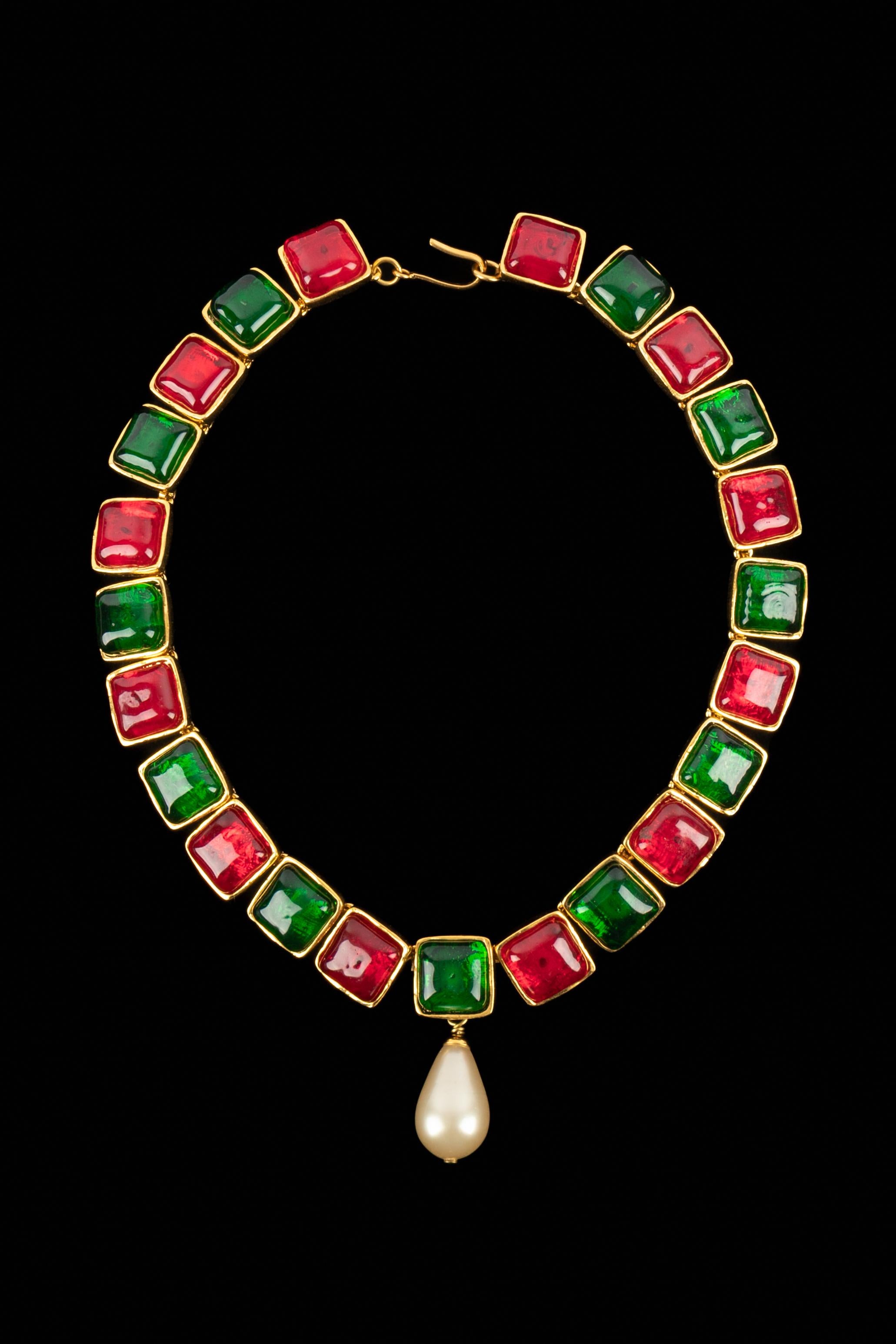 CHANEL - (Made in France) Collana articolata in metallo dorato con cabochon in pasta di vetro rossa e verde. Pezzo centrato con una goccia di perle in costume. Collezione Primavera-Estate 1993 sotto la direzione artistica di Karl