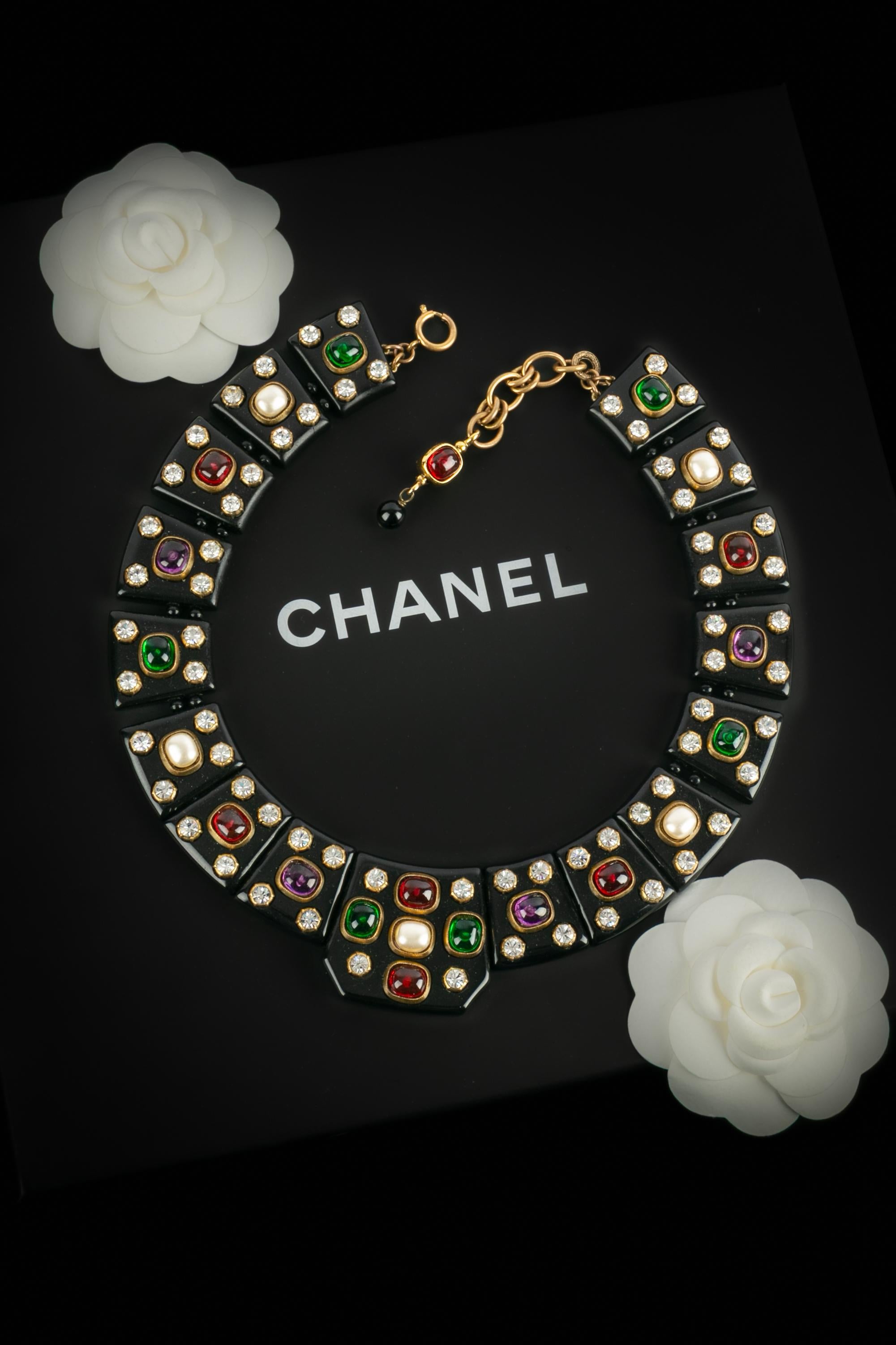 Chanel - Collana in metallo dorato e bachelite nera con cabochon perlati in costume e pasta di vetro multicolore. Collezione Autunno-Inverno 1985, sotto la direzione artistica di Karl Lagerfeld. Lavoro dalla casa di Woloch.

Condizioni:
Ottime