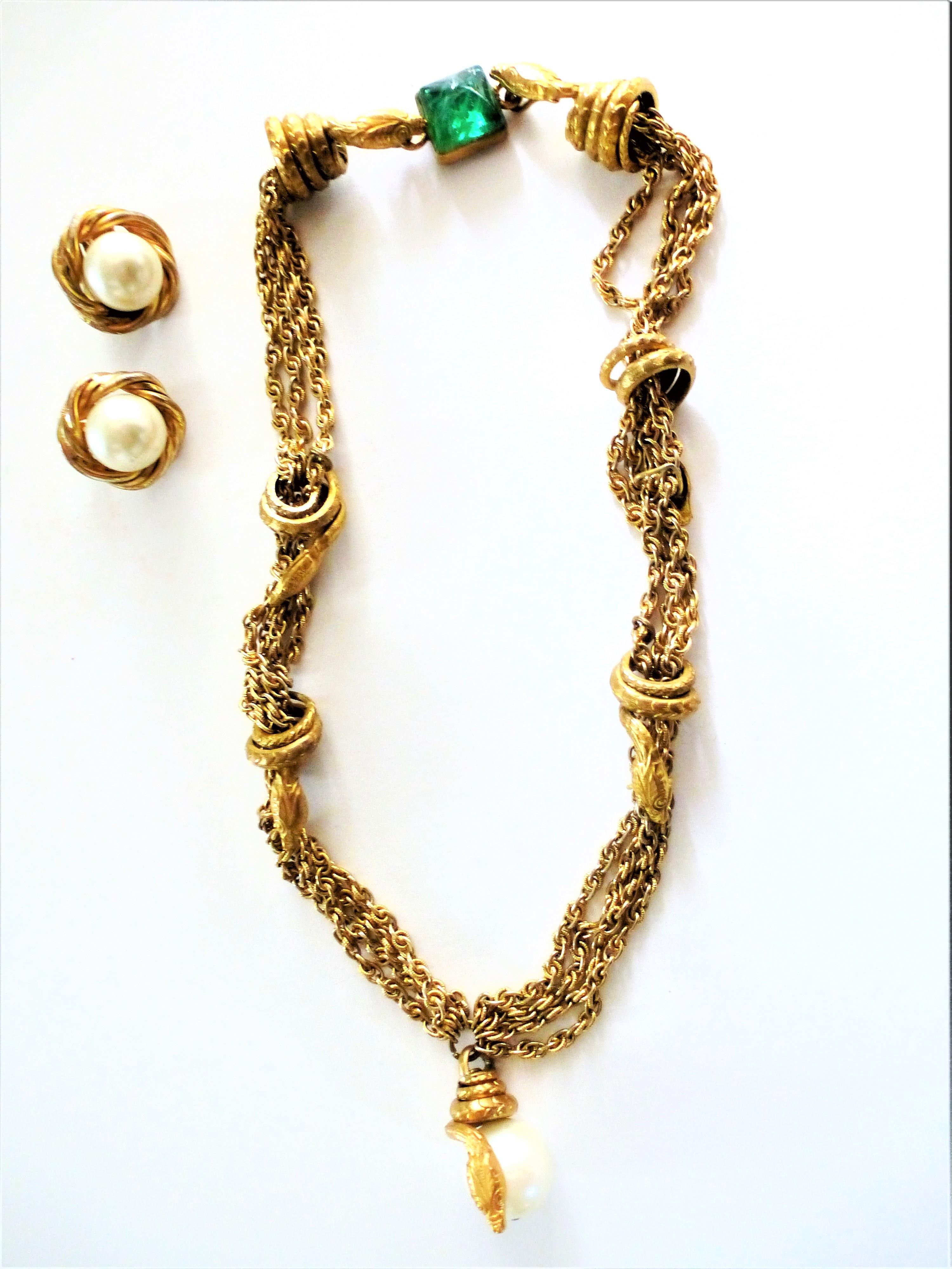 A rare snake necklace designed by Coco Chanel in the 1960s.  7 snakes wind around  each 4 fine chains. A loop has a large pearl in the mouth. The shutter is a green lake by Gripoix and 2 snakes hook each other. It is a typical wonderful early Chanel