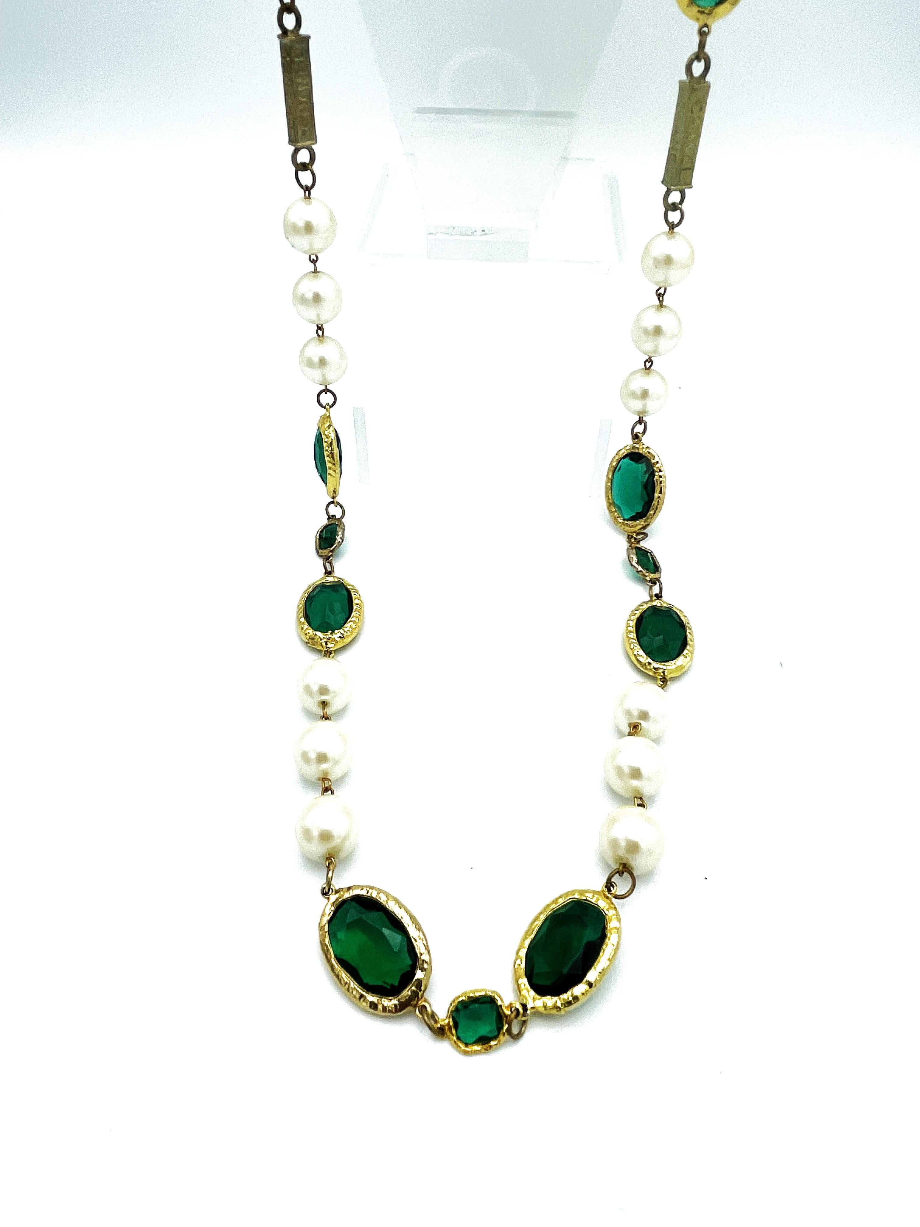 This rare long Chanel necklace or Sautoir consists of 18 large and well-preserved artificial pearls. 
In between 12 large oval green rhinestones from Swarovski with different cuts on each side, which are set in 24 carat gold. 
Between each two large