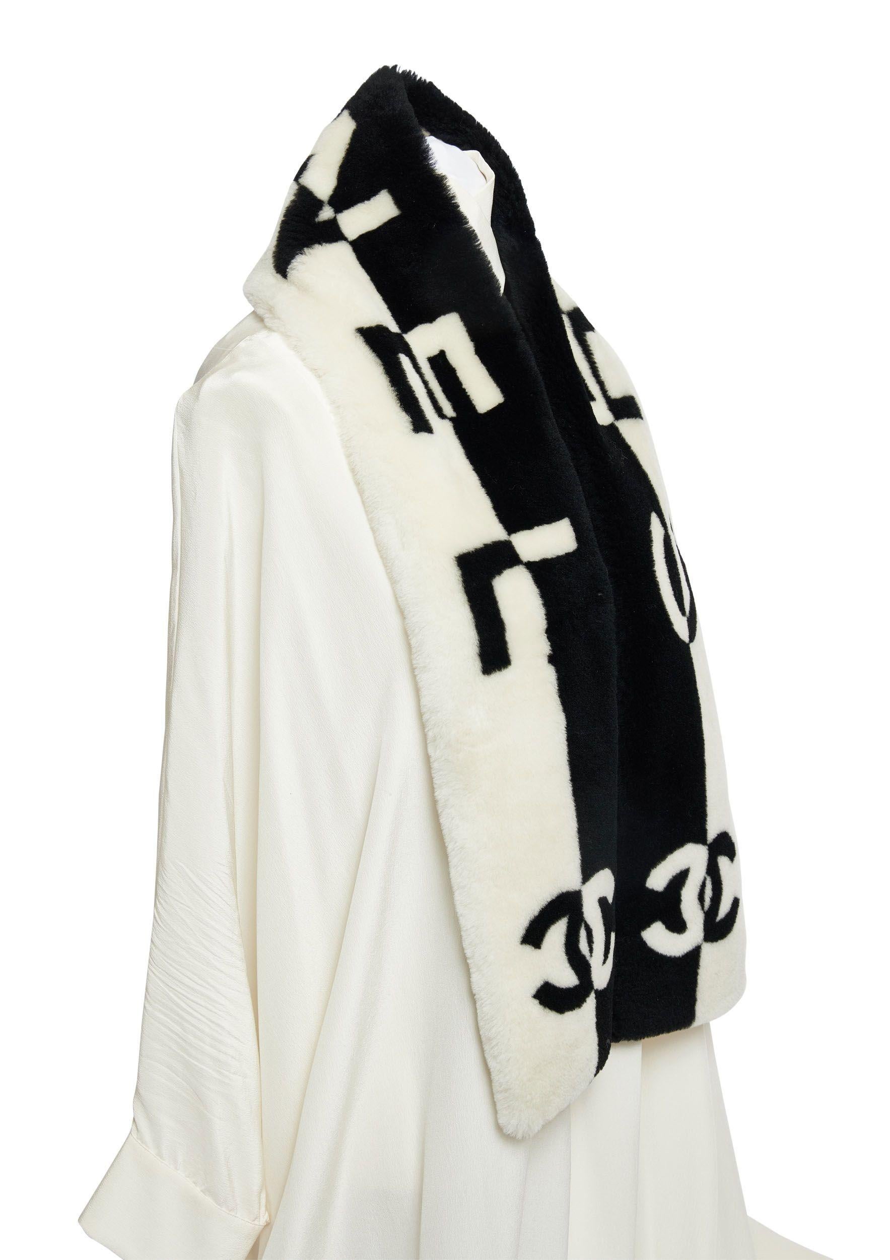 Nouvelle écharpe en peau de mouton noire et blanche de Chanel avec les lettres Chanel et le logo CC en contraste noir et blanc.
Doublure en cachemire.