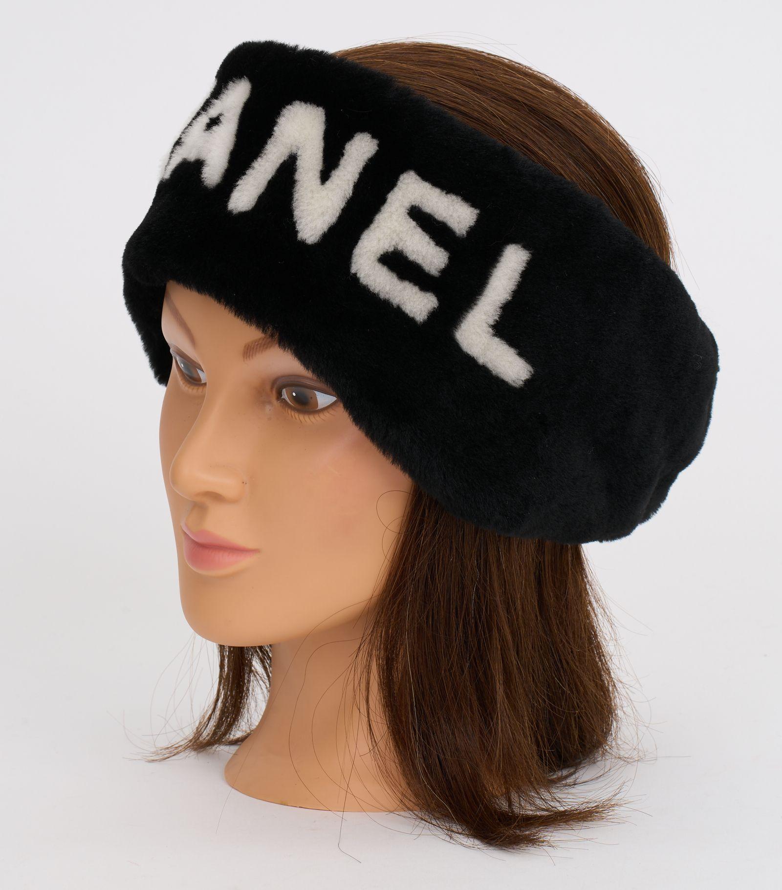 This Chanel black shearling headband features the white Chanel logo text against the black headband, and elasticity makes it adjustable to for most head sizes.