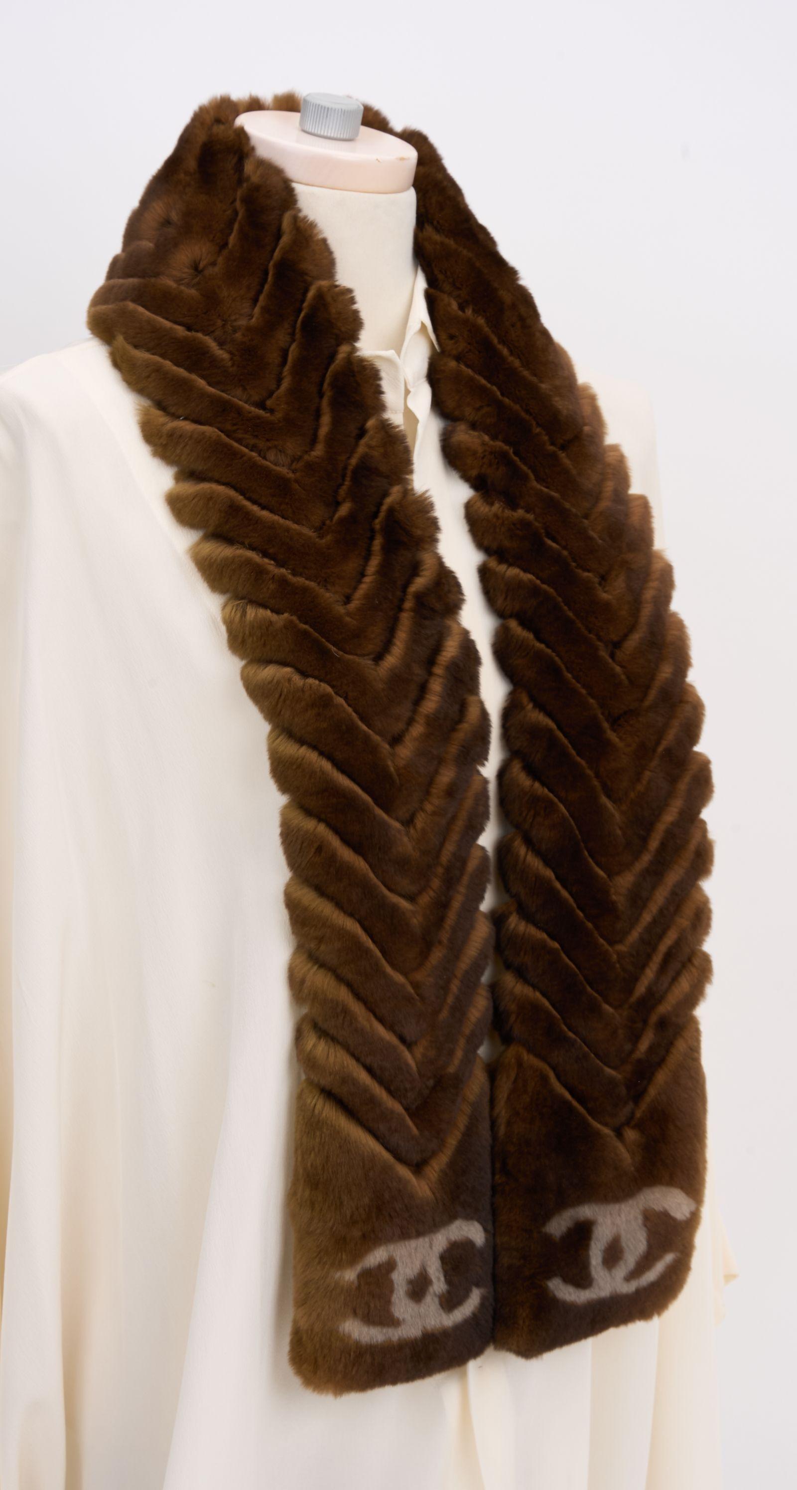 Este pañuelo Chanel Chinchilla Orylag es ultrasuave y presenta un bonito color marrón y el logotipo CC entrelazado en ambos extremos del pañuelo. Es el accesorio perfecto para las salidas invernales de lujo. Nuevo sin usar.