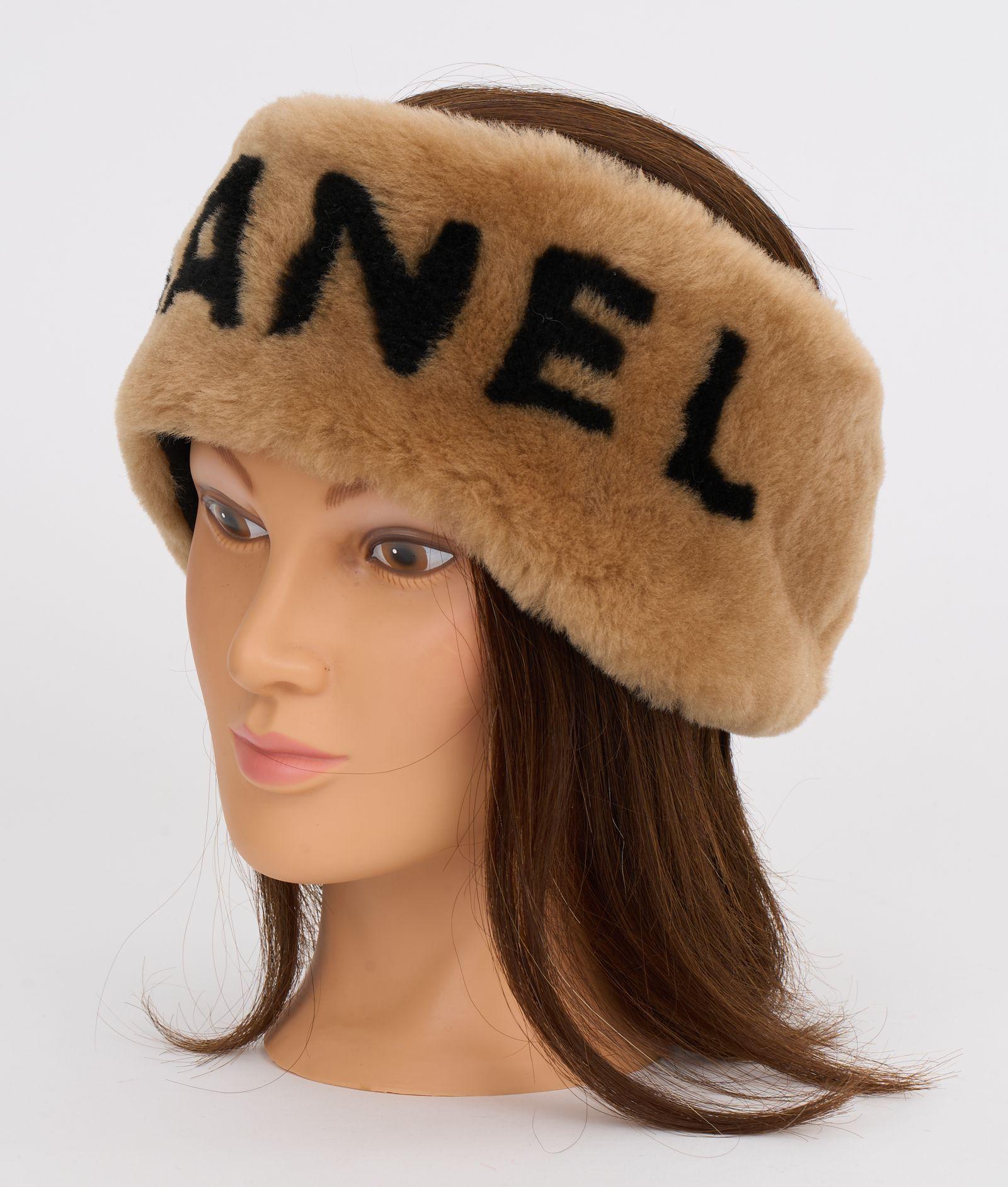 This Chanel brown shearling headband features the black Chanel logo text against the brown headband, and elasticity makes it one size and adjustable for most head sizes. Brand new in unworn condition.
