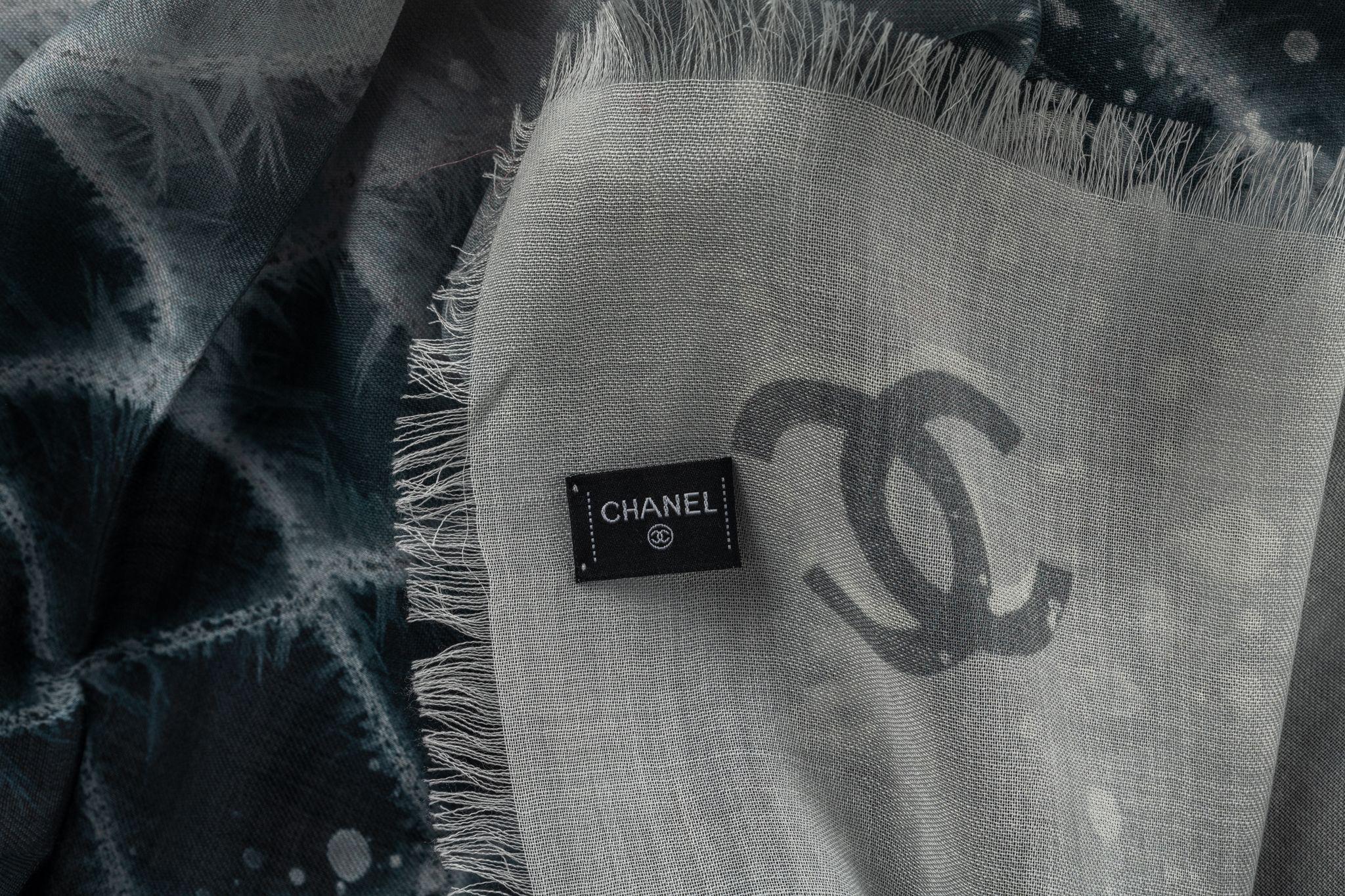 Chanel cashmere shawl in black. The pattern features a checkered design in a dark blue , black and a CC logo. The item is in new condition.