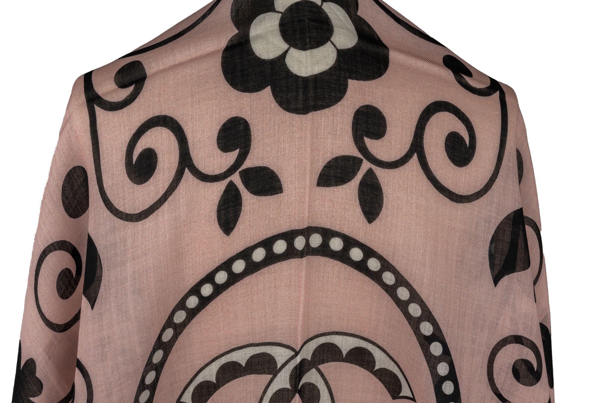 Chanel Cashmere Shawl in Rosé. the pattern features a big CC logo in the center surrounded by a flower arrangement. The item is in new condition.