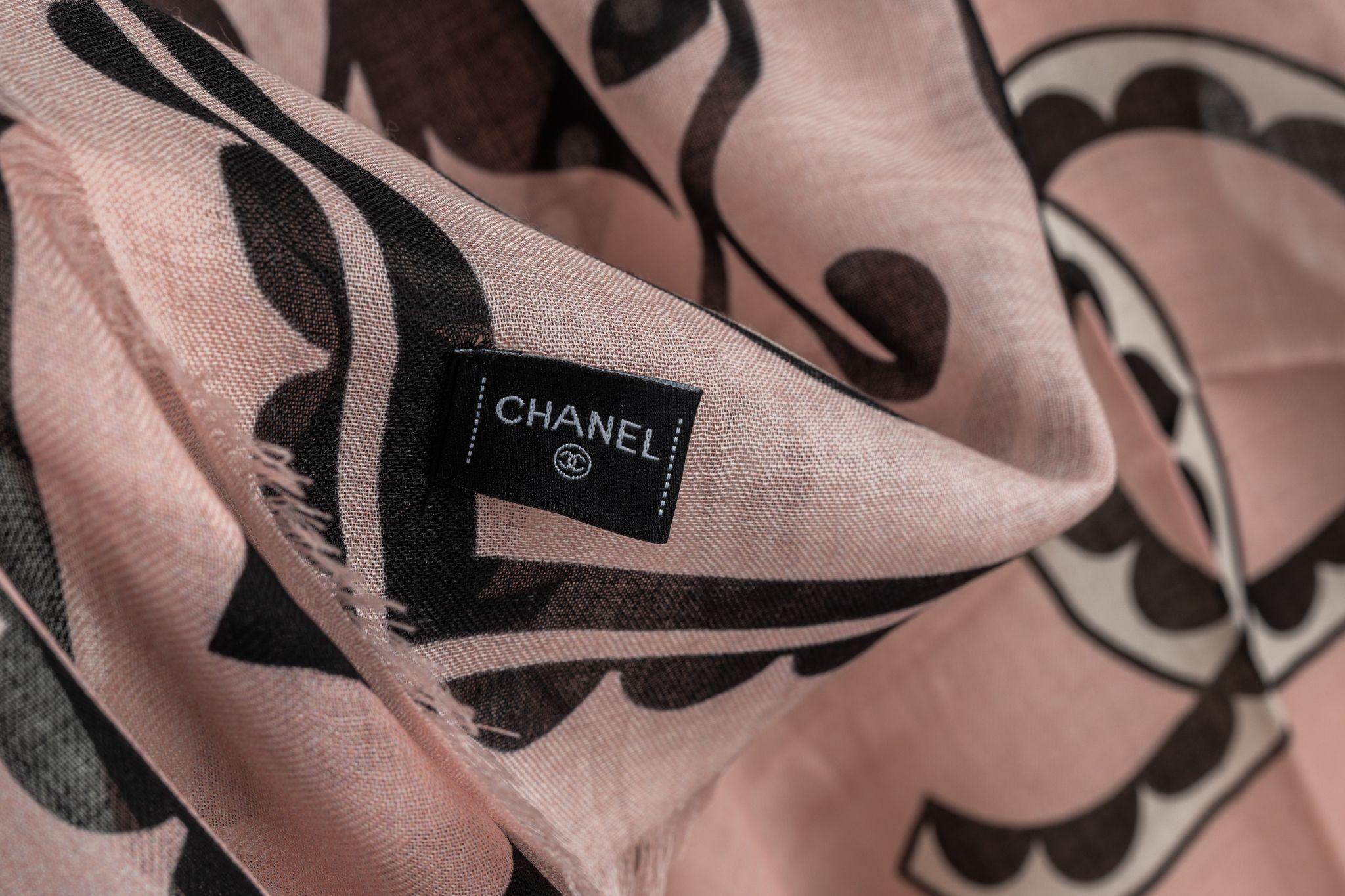 Chanel Cashmere Shawl in Rosé. the pattern features a big CC logo in the center surrounded by a flower arrangement. The item is in new condition.