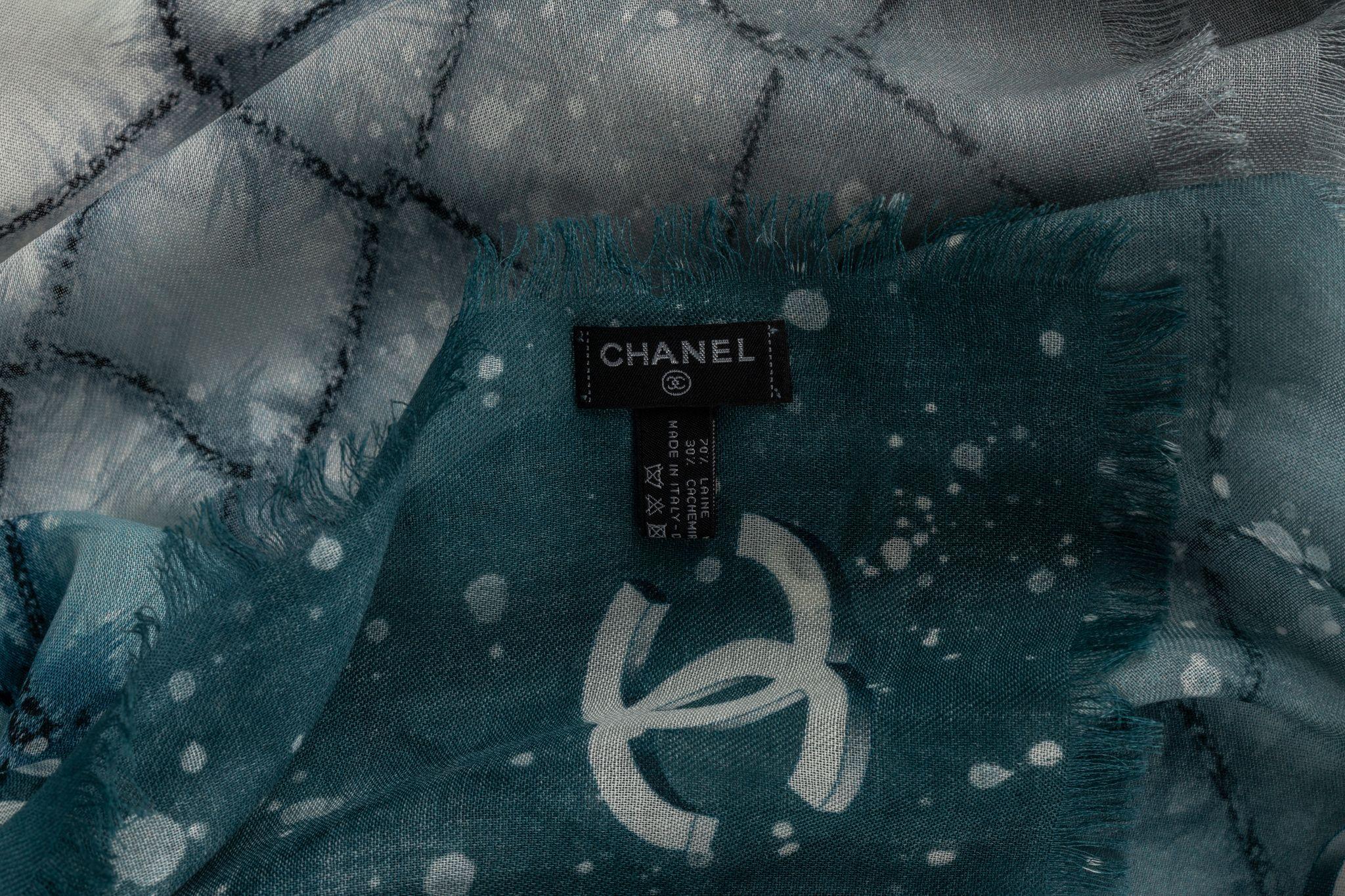 Chanel cashmere shawl in white with blue . The pattern features a checkered design in a blue and a CC logo frame. The item is in new condition.