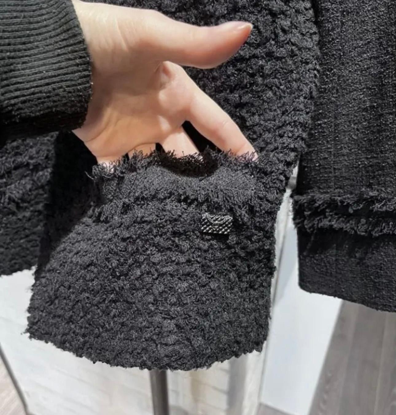 Neue zeitlose schwarze Chanel Jacke aus Boucle-Tweed. 
- CC Logo 'bag' Charme Verzierung an der Tasche
- Frontreißverschluss
- CC-Reißverschluss-Akzente an den Ärmeln
- schwarzes Seidenfutter
Größenbezeichnung 36 FR. 
