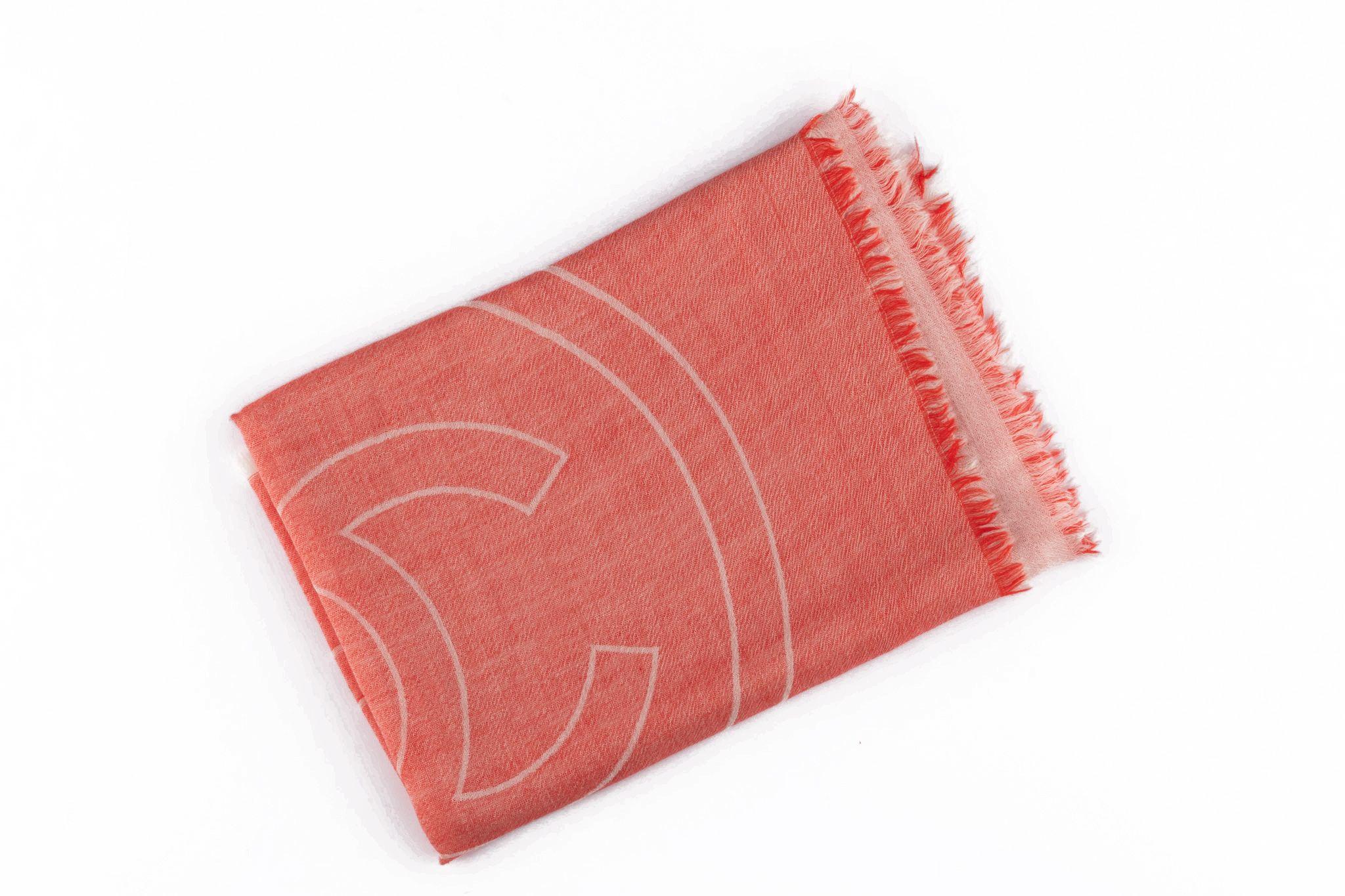 Este chal de cachemira con logotipo CC de Chanel es de un precioso rojo coral con un acento en crema del logotipo CC. Ligero y con unas medidas de 78