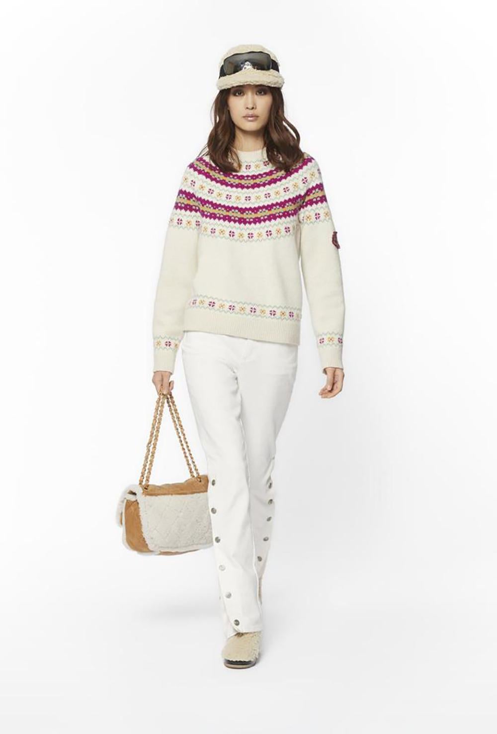 New Chanel ecru knit pullover from COCO Neige 2021 Collection. CC logo patch at sleeve. Size mark 42 FR. Comes with paper Chanel pouch with extra knit.