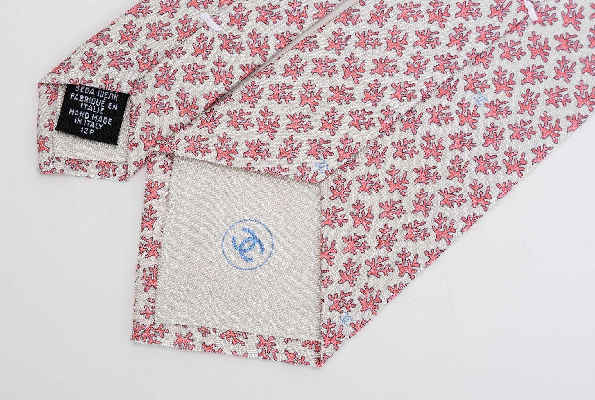 Chanel brand new 100% silk tie in cream and pink coral branch pattern. Composition label, brand label and signature chain. Comes with original envelope .