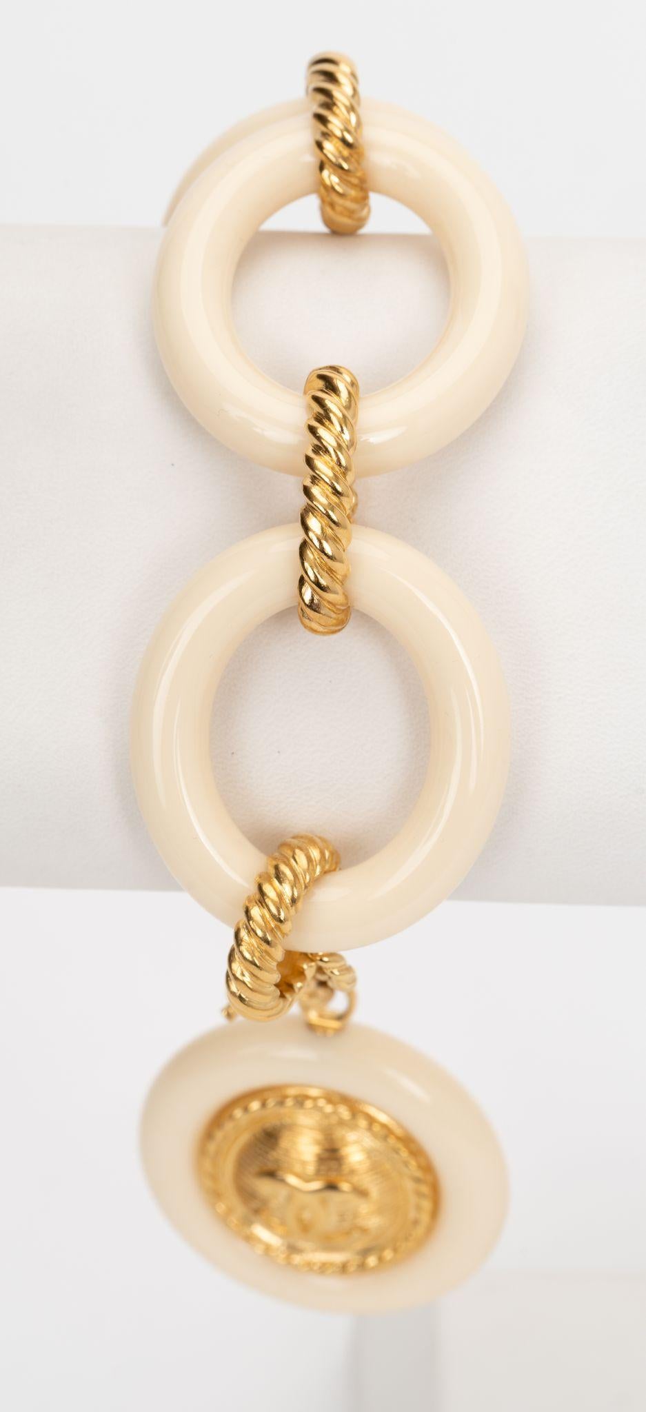 Chanel neues übergroßes Armband mit Charme aus cremefarbenem Kunststoff und goldenem Metall. Ungetragener Zustand. 
Collection'S Herbst 2016.
Kommt mit Booklet und Originalverpackung.