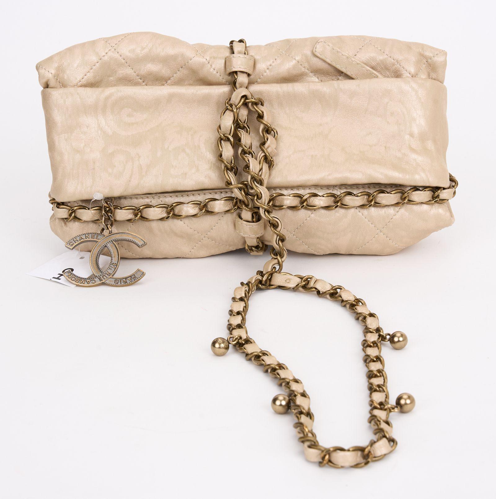 This Chanel Calfskin Quilted Baluchon features semi-distressed diamond stitched luxurious calfskin leather. This shoulder bag has a gold chain threaded with leather tied like a parcel with an extended length for top handles. The bag is opened with a