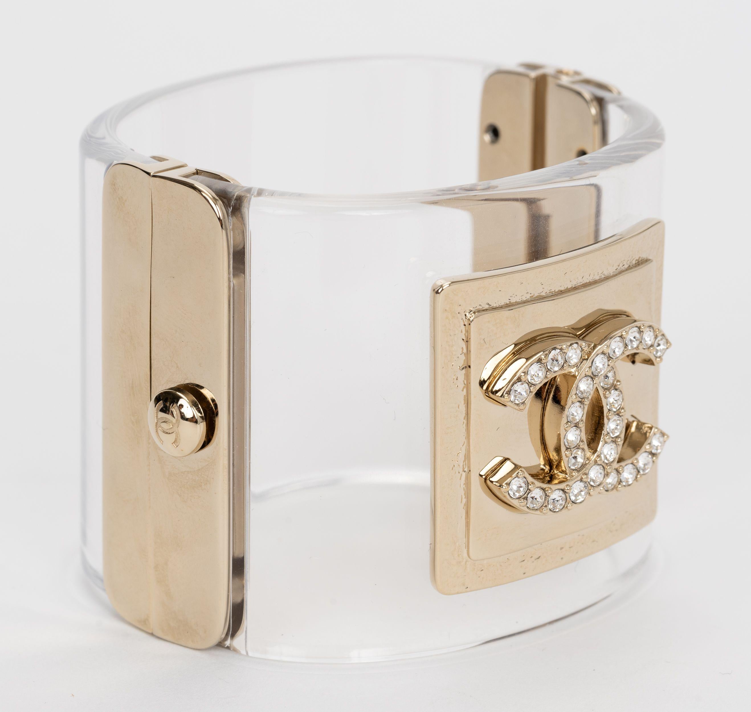 The Spring 2023 Resin and Strass CC Cuff is by Virginie Viard Collection. Clear lucite with gold tone hardware and rhinestone cc logo. Size small. Brand new with original box and duster.