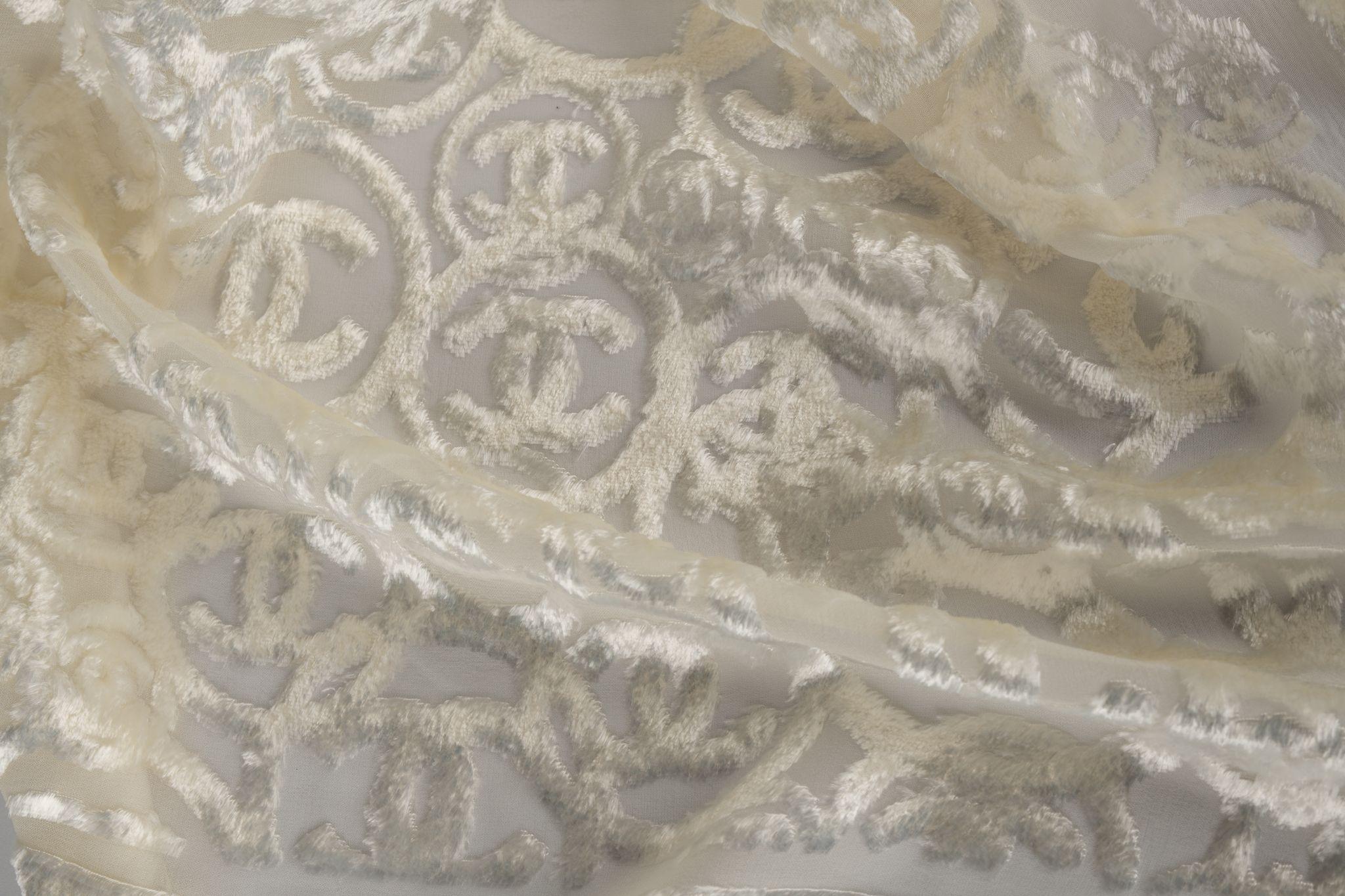 Chanel silk-blend stole in cream white with a shiny pattern of CC logos. The item is in new condition.