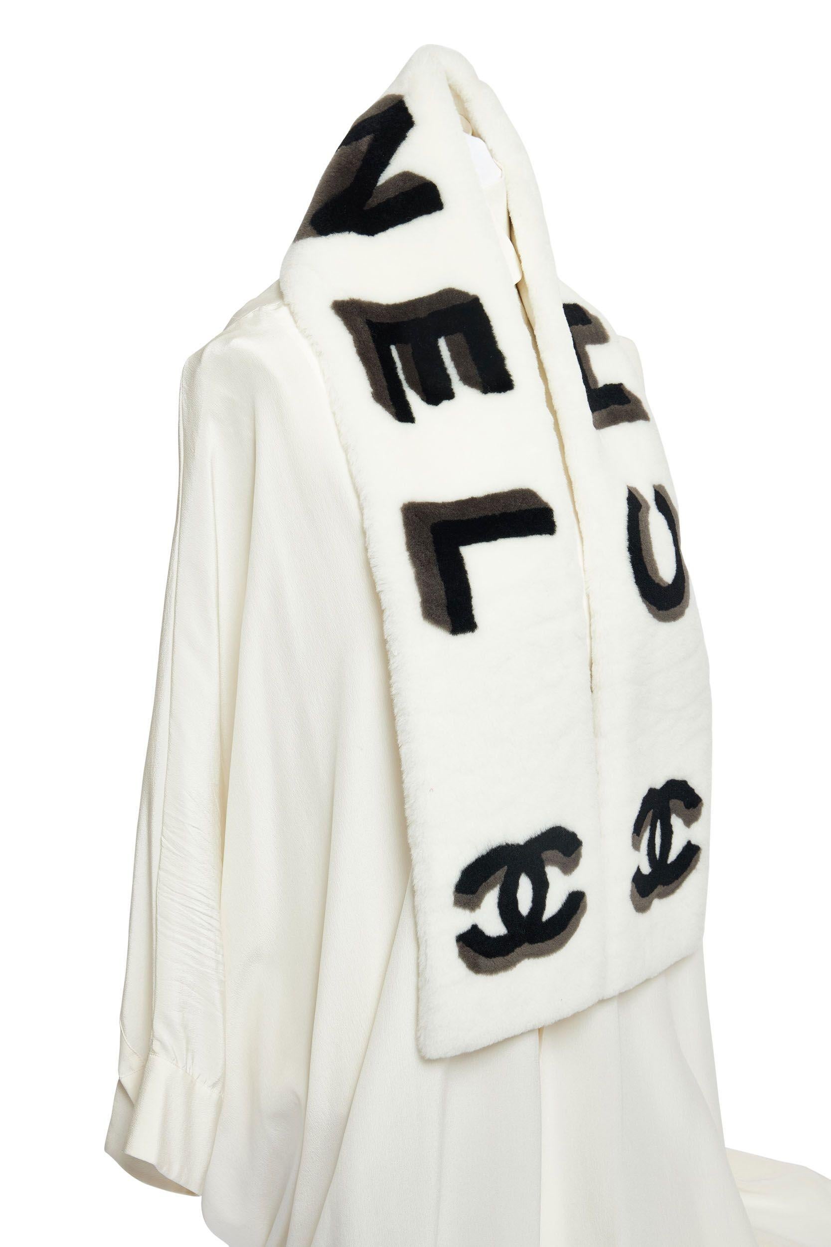New Chanel white sheepskin scarf with black and grey three-dimensional Chanel letters and CC logo. Warm white cashmere lining.