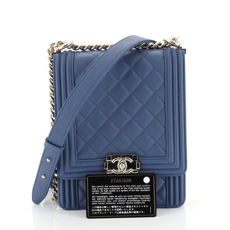 This Chanel North South Boy Flap Bag Quilted Calfskin Small, crafted from blue quilted calfskin leather, features chain link strap with adjustable leather pad and gold-tone hardware. Its CC boy push lock closure opens to a blue fabric interior with
