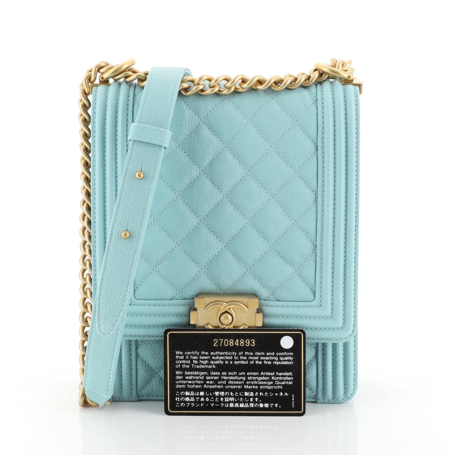This Chanel North South Boy Flap Bag Quilted Caviar Small, crafted from blue quilted caviar leather, features chain link strap with adjustable leather pad and matte gold-tone hardware. Its CC boy push lock closure opens to a blue fabric interior