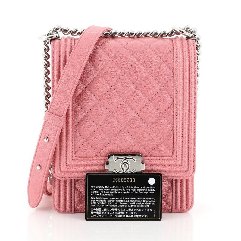 This Chanel North South Boy Flap Bag Quilted Caviar Small, crafted from pink quilted caviar leather, features chain link strap with adjustable leather pad and silver-tone hardware. Its CC boy push lock closure opens to a pink fabric interior with