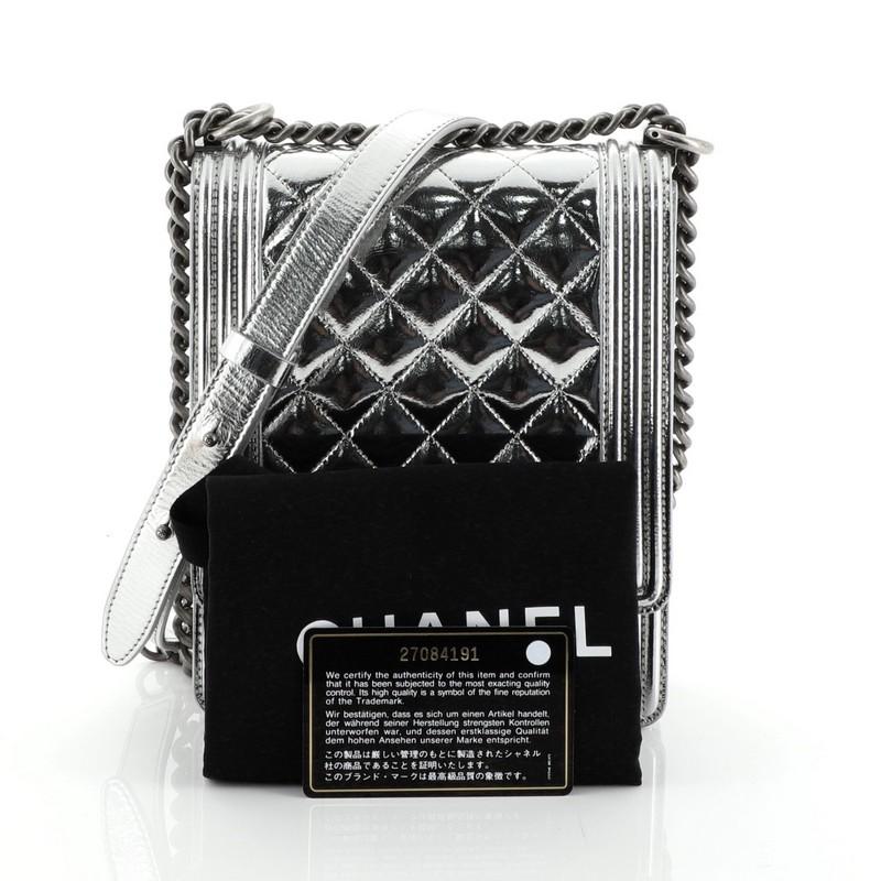 This Chanel North South Boy Flap Bag Quilted Metallic Calfskin Small, crafted from metallic silver quilted calfskin leather, features chain link strap with adjustable leather pad and aged silver-tone hardware. Its CC boy push lock closure opens to a