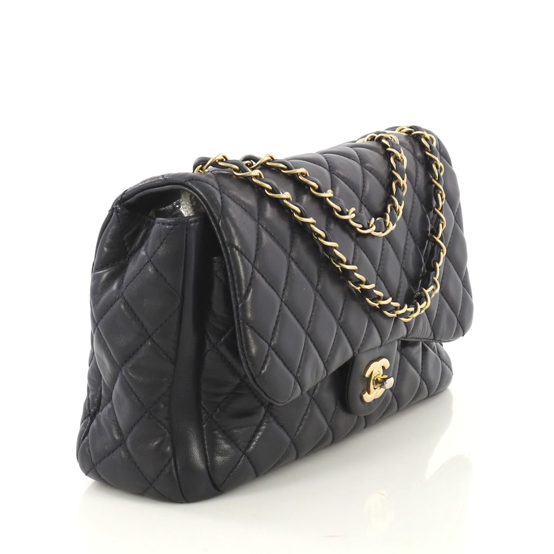 This Chanel Now and Forever Flap Bag Quilted Lambskin Jumbo, crafted from navy quilted lambskin leather, features woven-in leather chain strap, exterior back pocket, frontal flap, and gold-tone hardware. Its CC turn-lock closure opens to a navy