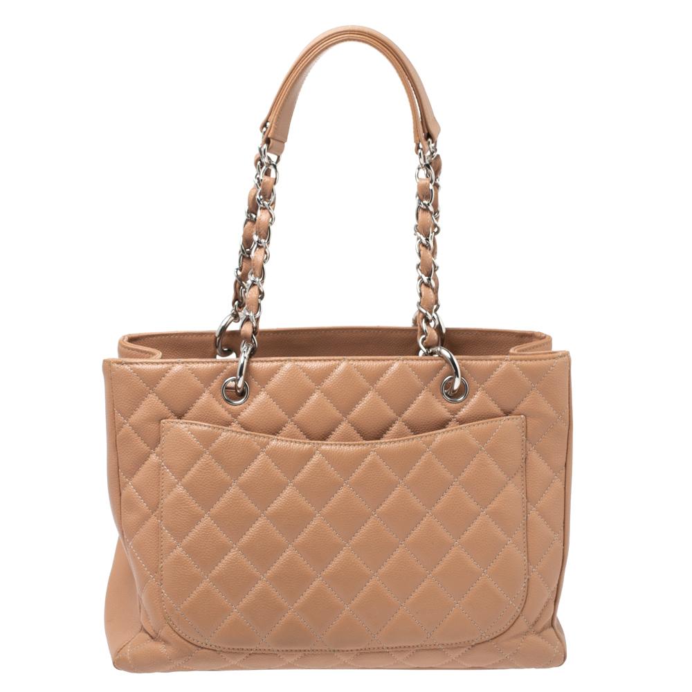 Featuring top handles with chain trim and the CC logo on a quilted pattern, this Chanel Nude Beige Caviar leather tote exudes just the right amount of sophistication. The bag features a spacious compartment divided by a zipper. It has an additional