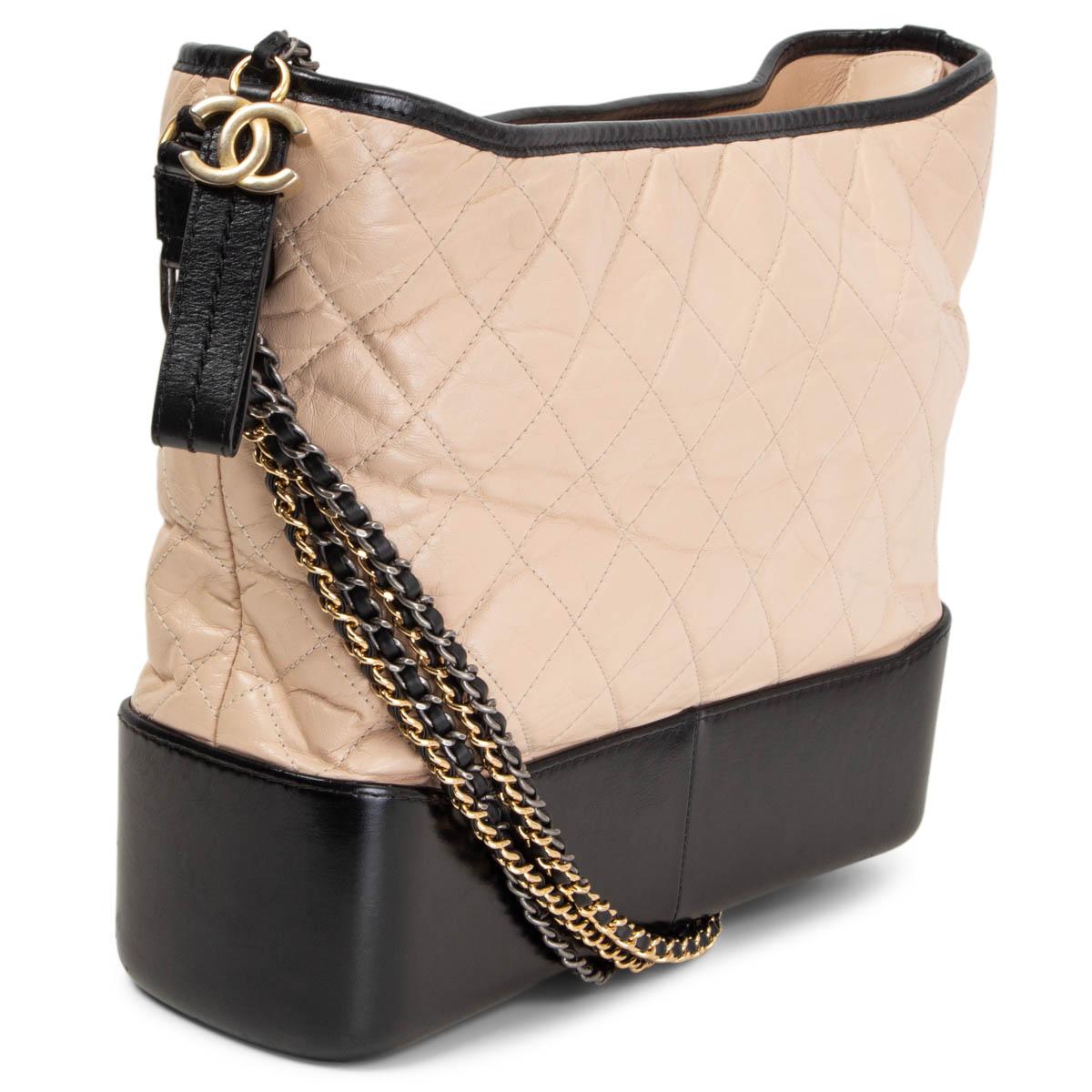 100% authentic Chanel Gabrielle Large Hobo Bag in nude aged calfskin and a black bottom smooth calfskin with trimmings and shoulder-strap. Lined in burgundy grosgrain with one zip pocket against the back and two open pockets against the front