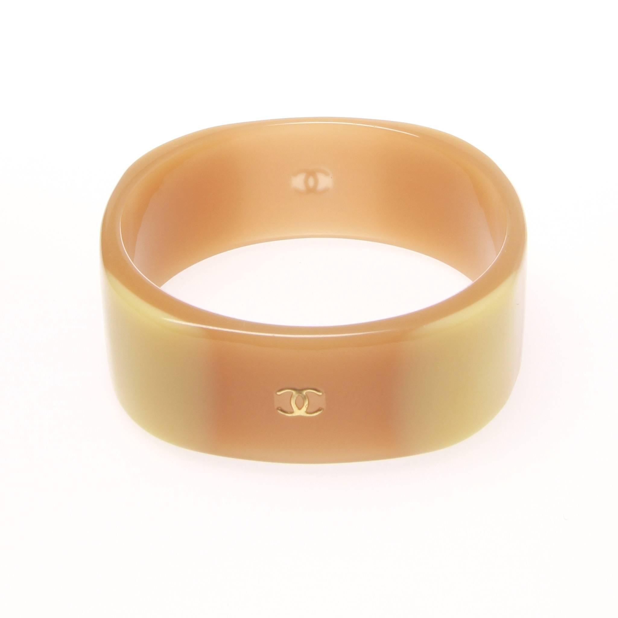 Chanel cuff in a nude caramel resin with a subtly inlaid gold-tone CC.

Stamped 06 A - Fall 06


