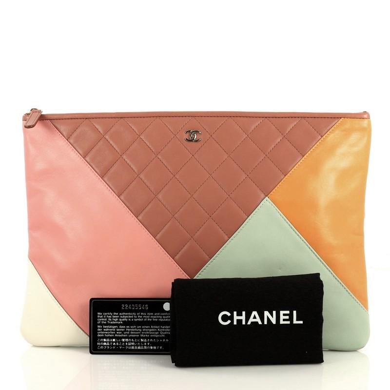 This Chanel O Case Clutch Colorblock Quilted Leather Large, crafted from multicolor quilted leather, features a tiny CC logo on the front and gold-tone hardware. Its zip closure opens to a brown nylon interior. Hologram sticker reads: 22405546.