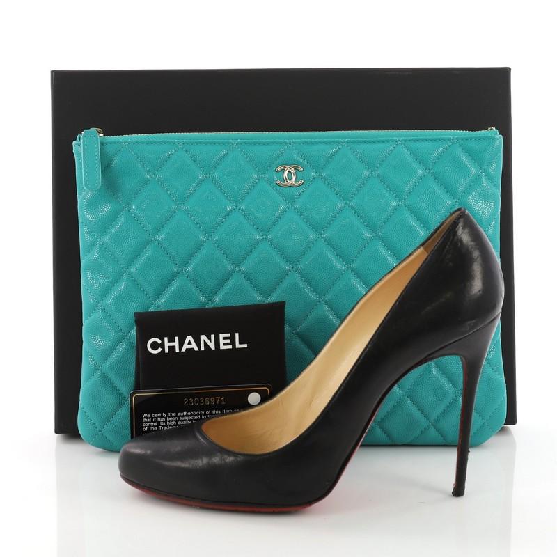 This Chanel O Case Clutch Quilted Caviar Medium, crafted in teal quilted caviar, features zip closure and opens with teal fabric interior with zip pocket. Hologram sticker reads: 23036971. **Note: Shoe photographed is used as a sizing reference, and