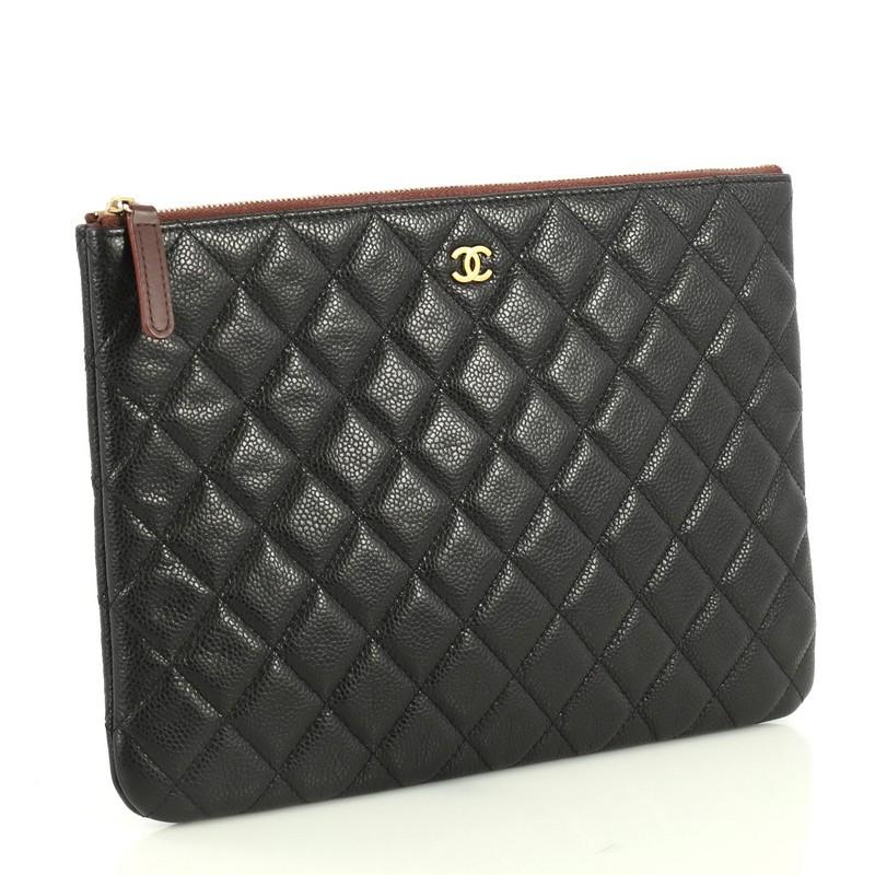 This Chanel O Case Clutch Quilted Caviar Medium, crafted from black quilted caviar leather, features a tiny CC logo on the front and gold-tone hardware. Its zip closure opens to a red nylon interior. Hologram sticker reads: 21702302. 

Estimated