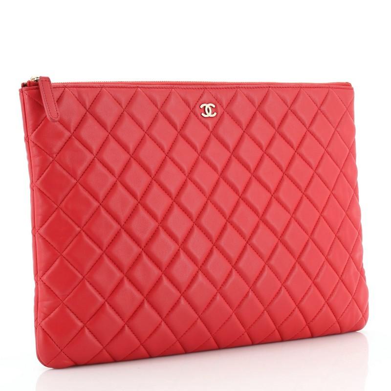 This Chanel O Case Clutch Quilted Lambskin Large, crafted from red quilted lambskin leather, features CC logo on the front, and gold-tone hardware. Its zip closure opens to a red nylon and fabric interior. Hologram sticker reads: 21881314.
